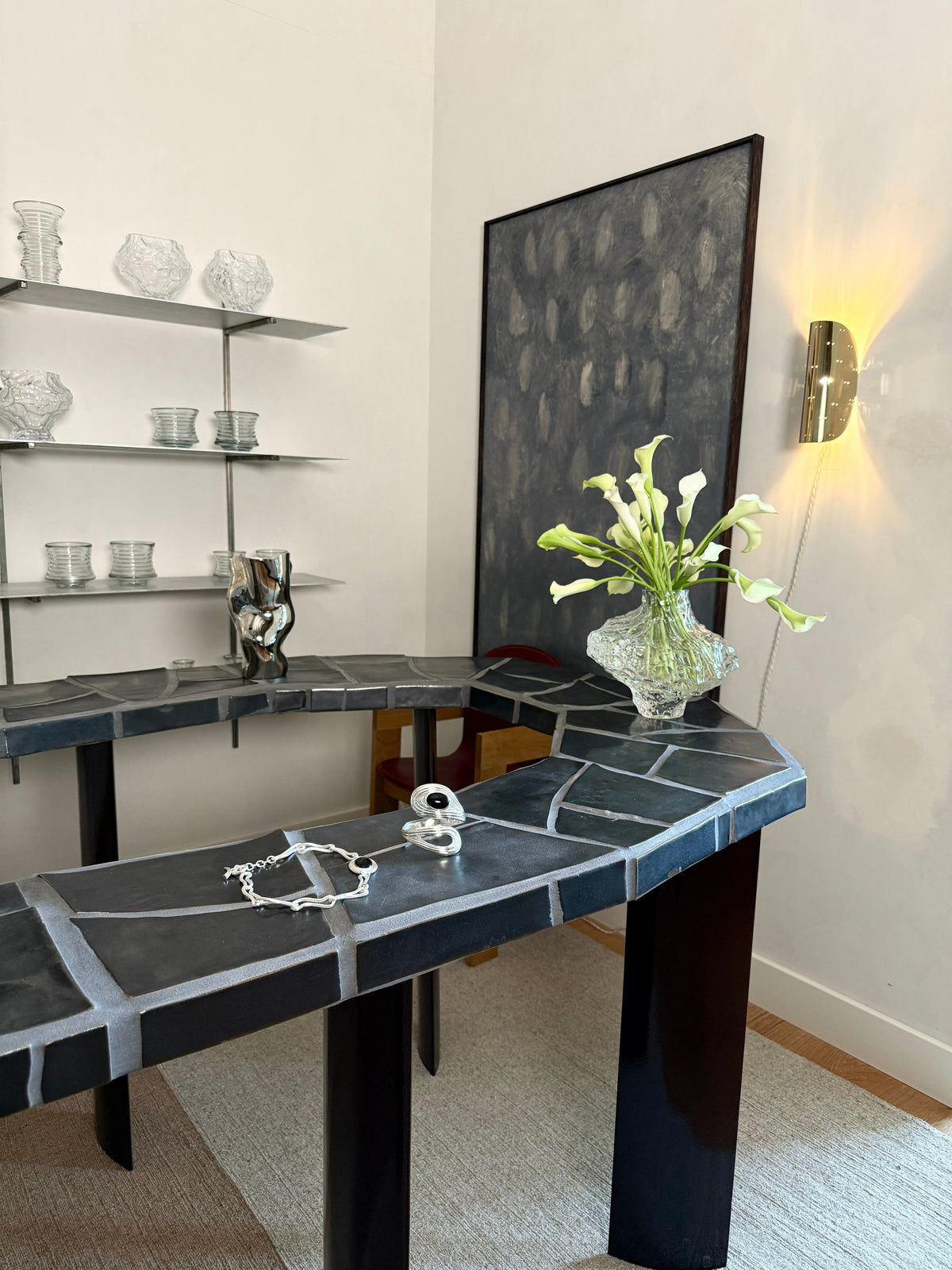 Giselle Wall Lamp - Polished Brass — mounted on wall above dark stone table