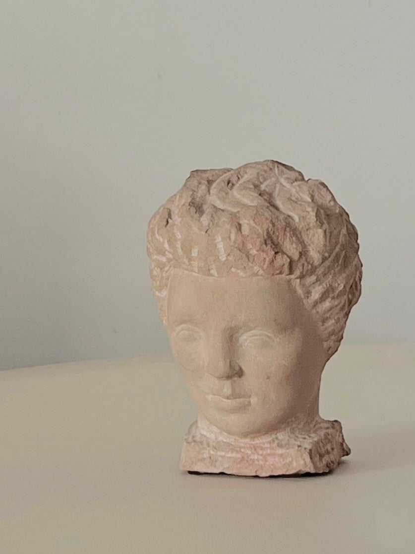 Detailed view of carved stone bust sculpture with curly hair by Helge Högbom