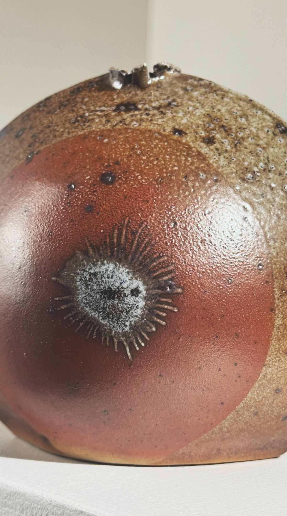 Close-up detail of ceramic sunflower motif on stoneware vase