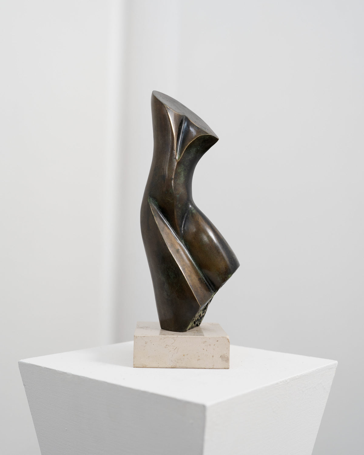 Abstract bronze sculpture with twisted angular forms on white base by Stanislaw Wysocki