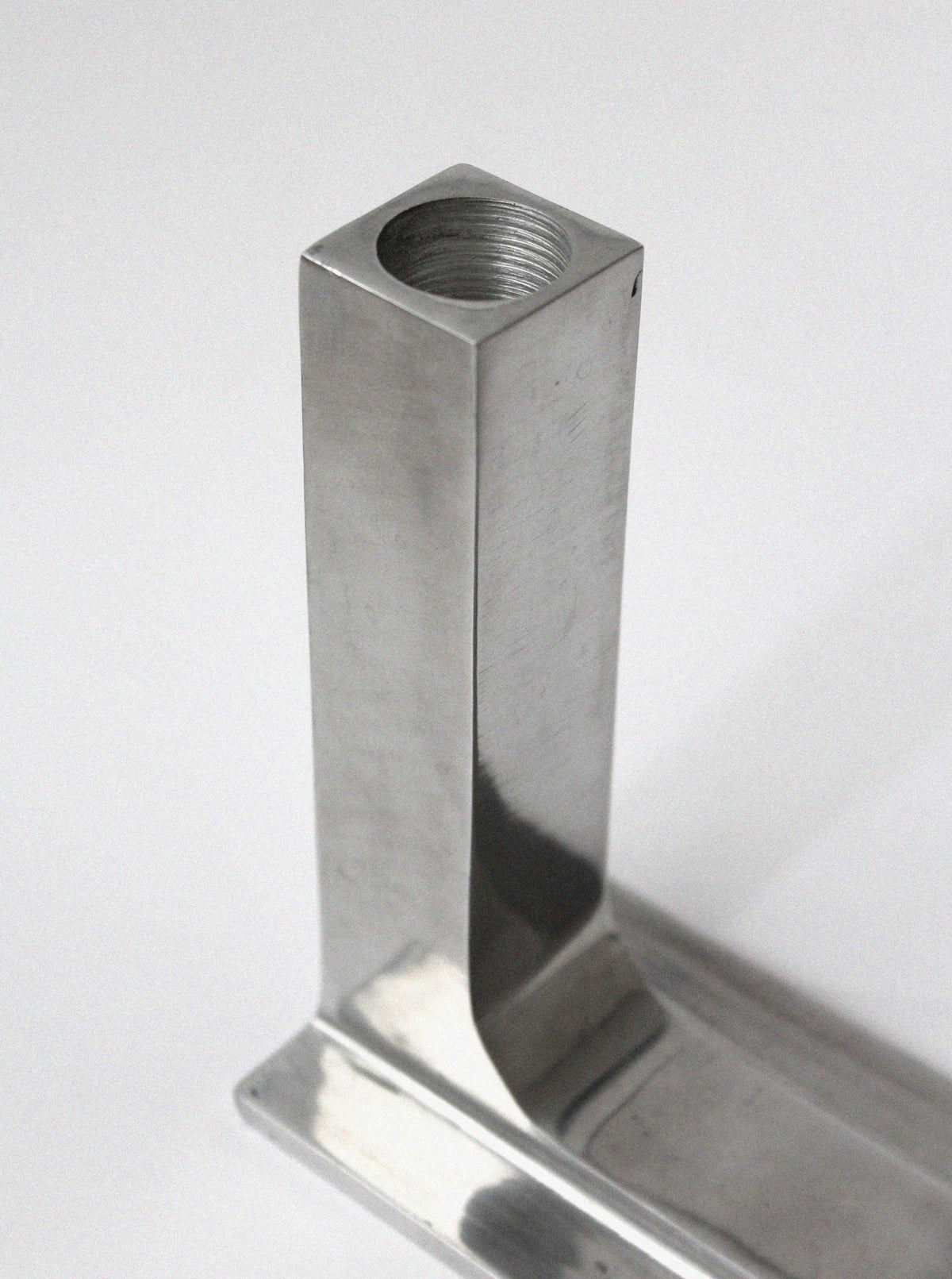 Brutalist aluminum candle holder showing threaded top detail