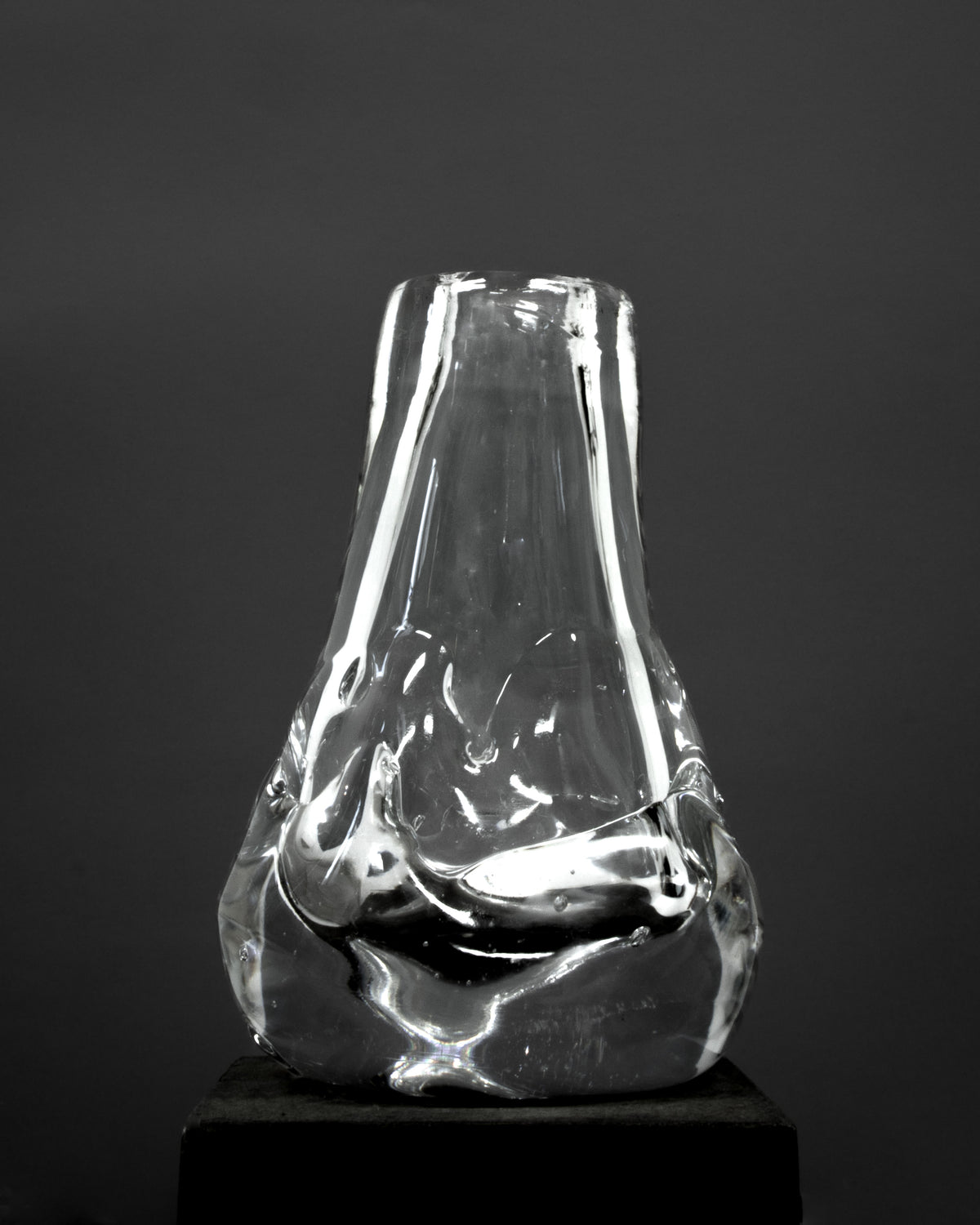 Drop Shaped Hand-blown Vase — clear glass vase on dark pedestal