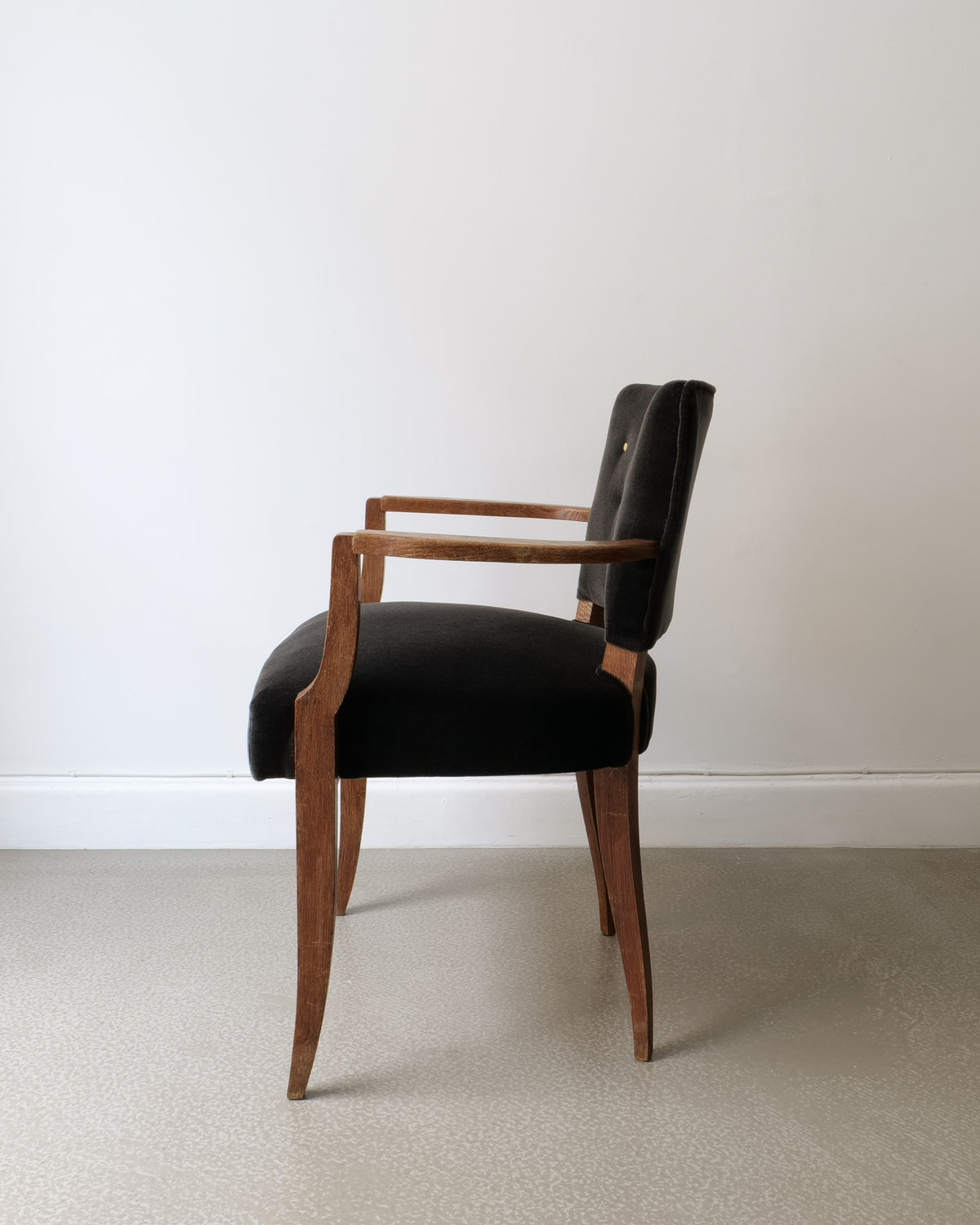 Side profile of 1930s French bridge chair with walnut frame and dark upholstery
