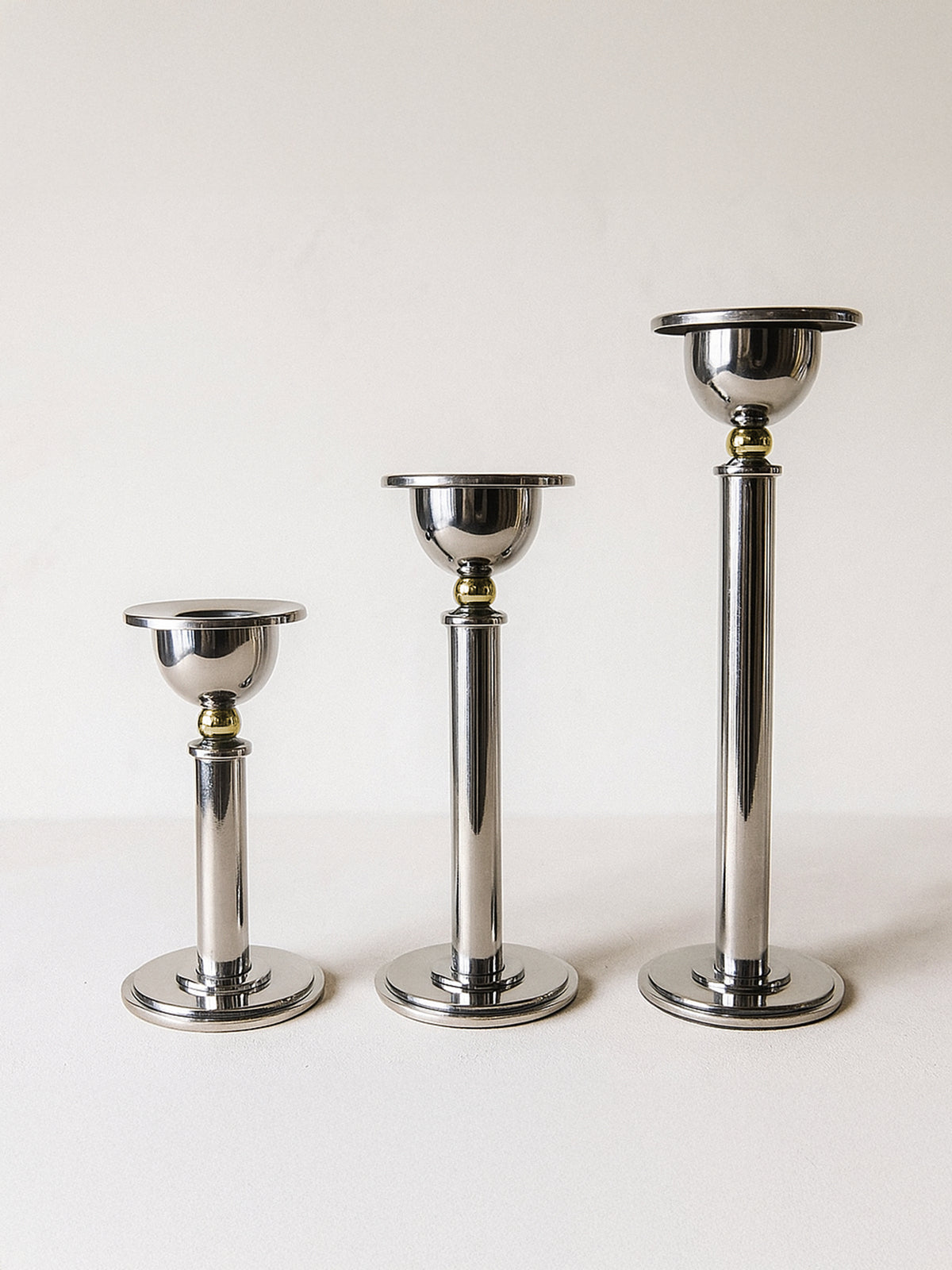 Three graduated silver postmodern candle holders from the 1980s