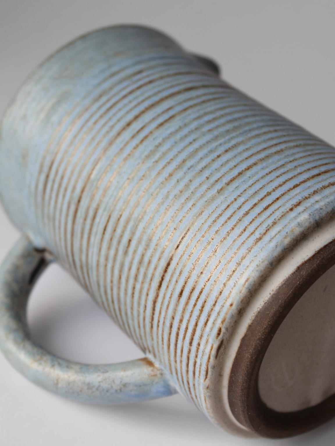 Close-up view of turquoise ceramic jug showing ribbed texture detail