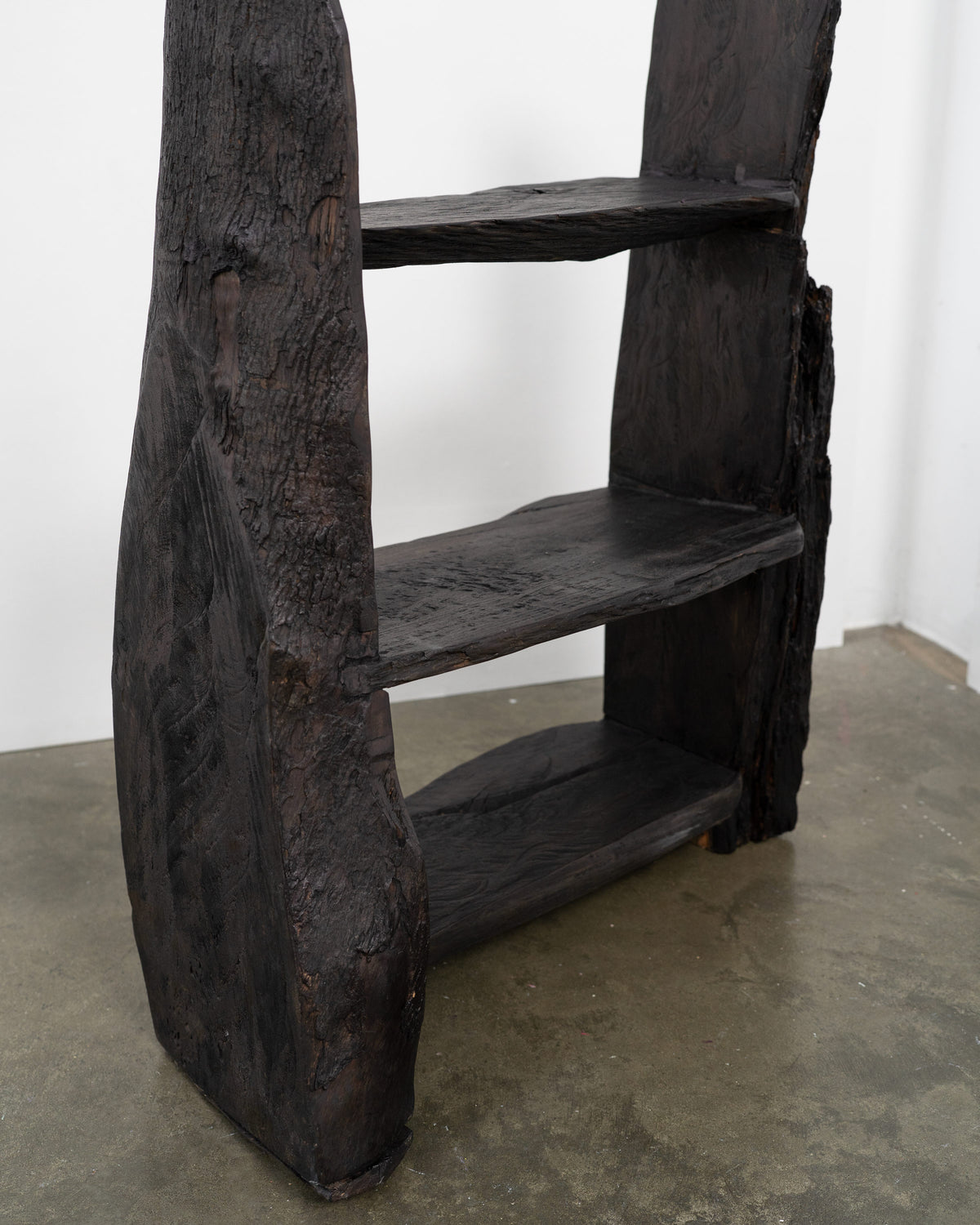 Charred wood brutalist bookcase with three shelves detail view