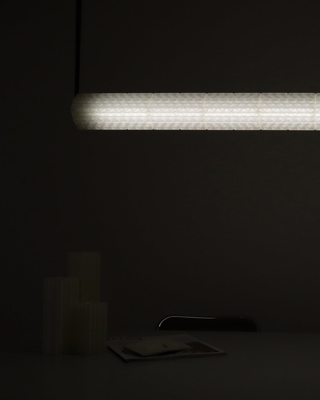 Goth pendant light illuminated against dark wall by Arthur Bitsch