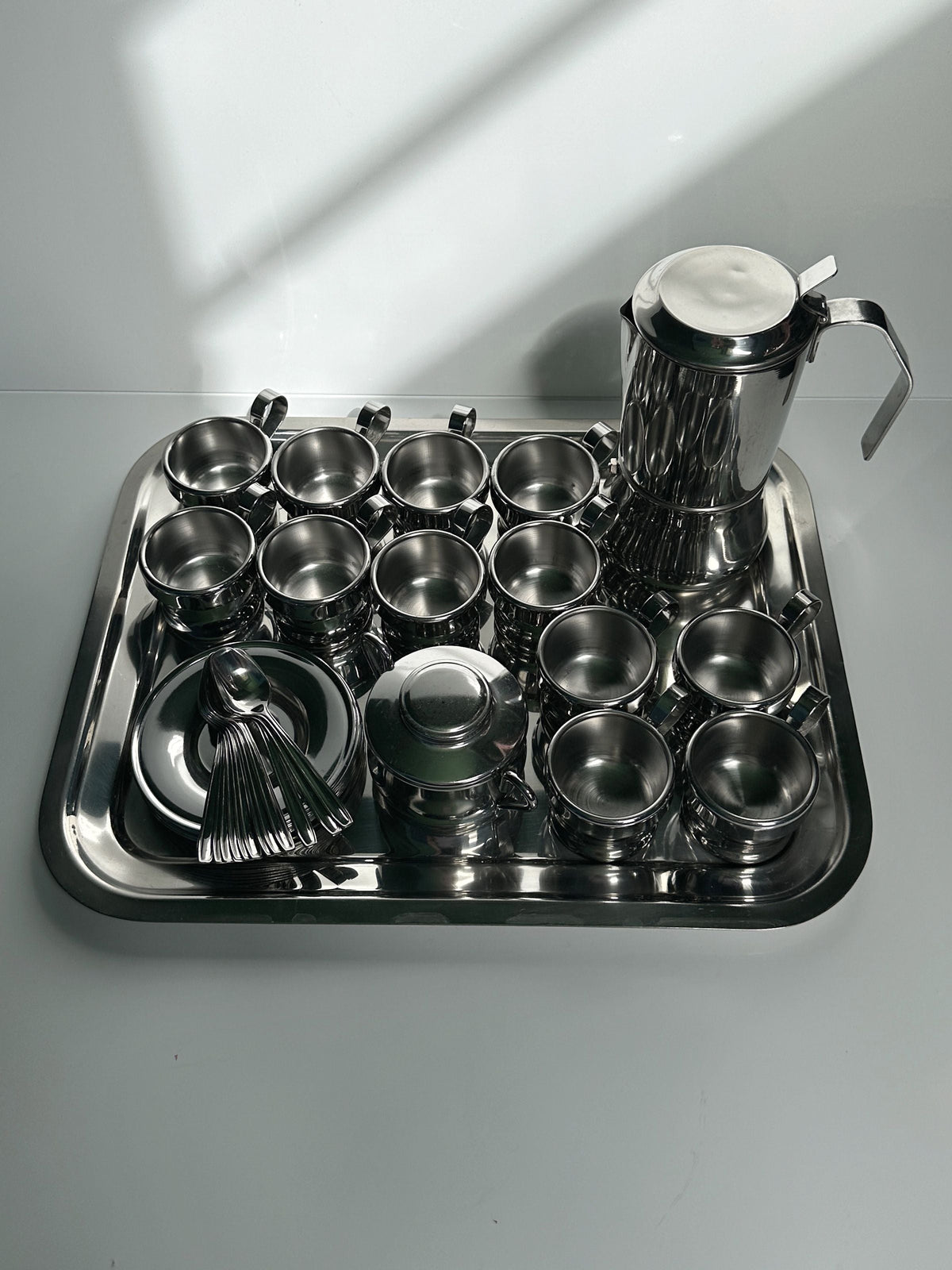 Italian Stainless Steel Coffee Set for 12 Persons — side angle on reflective tray