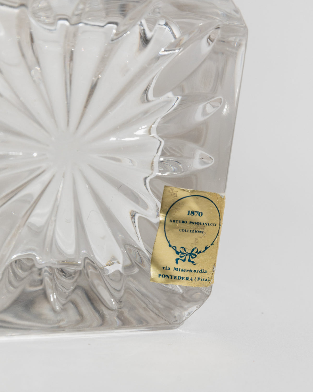 Close-up detail of vintage glass decanter with 1970 Pasquinucci label