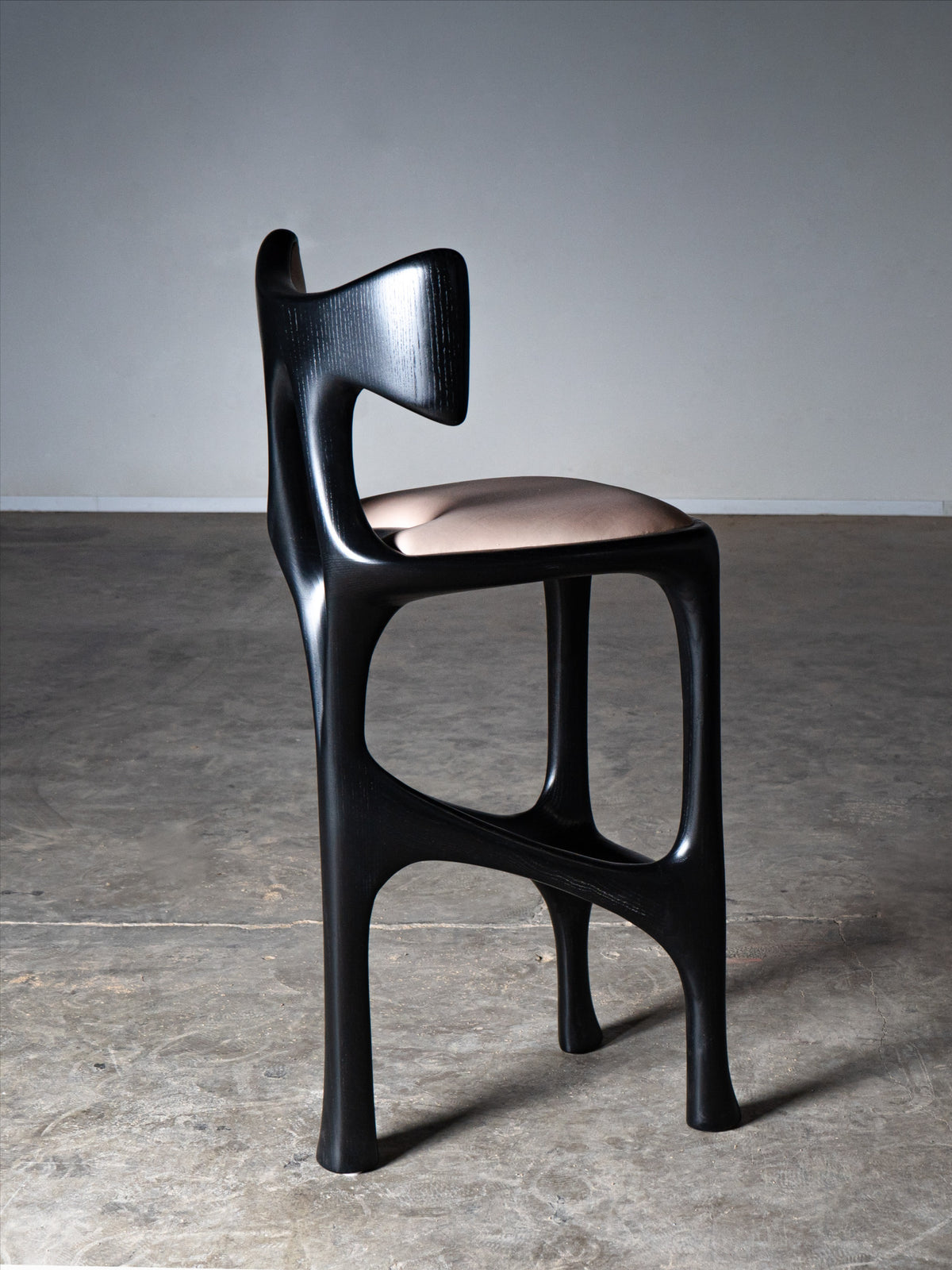 Tripa Stool in Ebony stain on Ash Wood — side view highlighting curved backrest