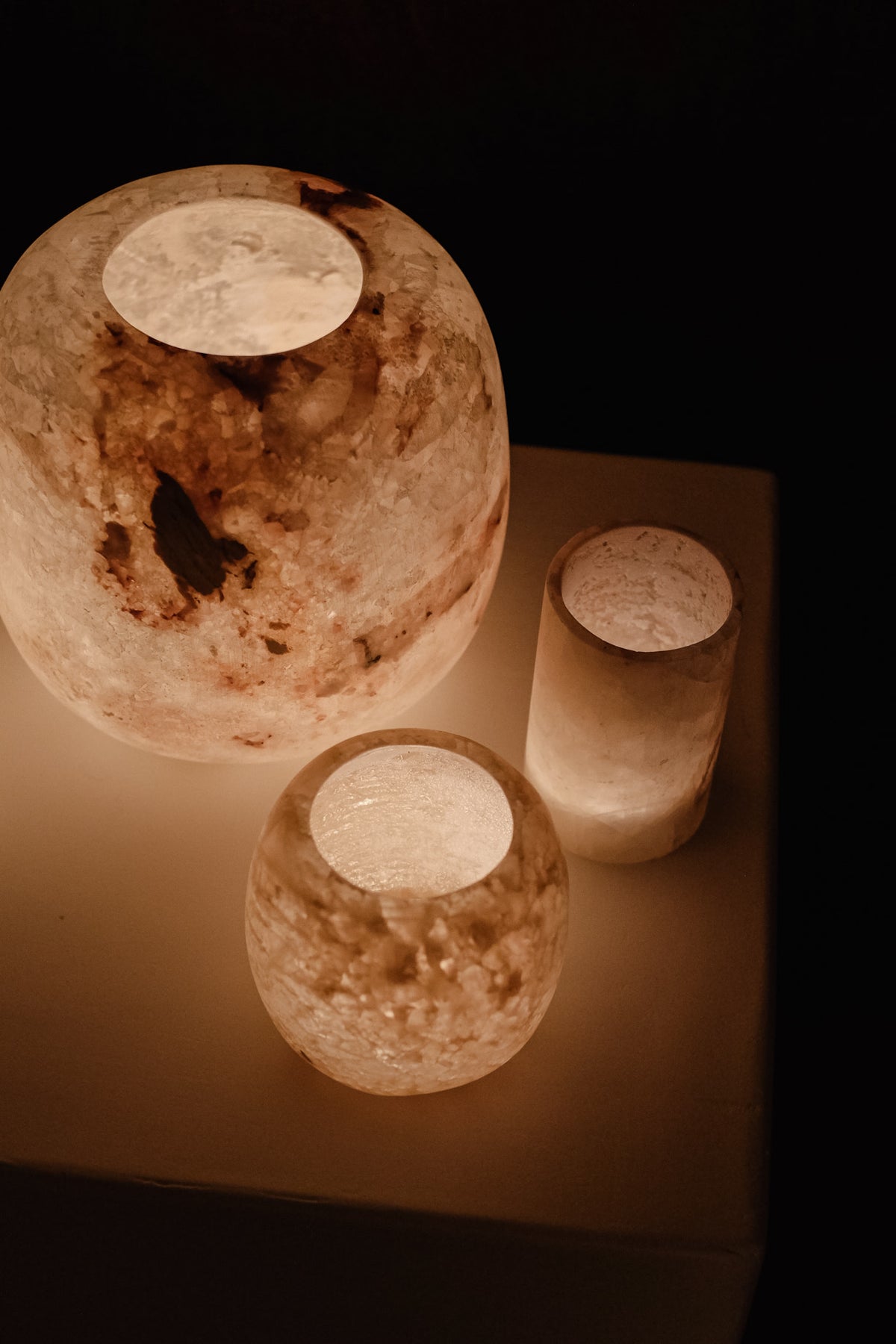 Alabaster Candle Holder — side angle with warm glow on white surface
