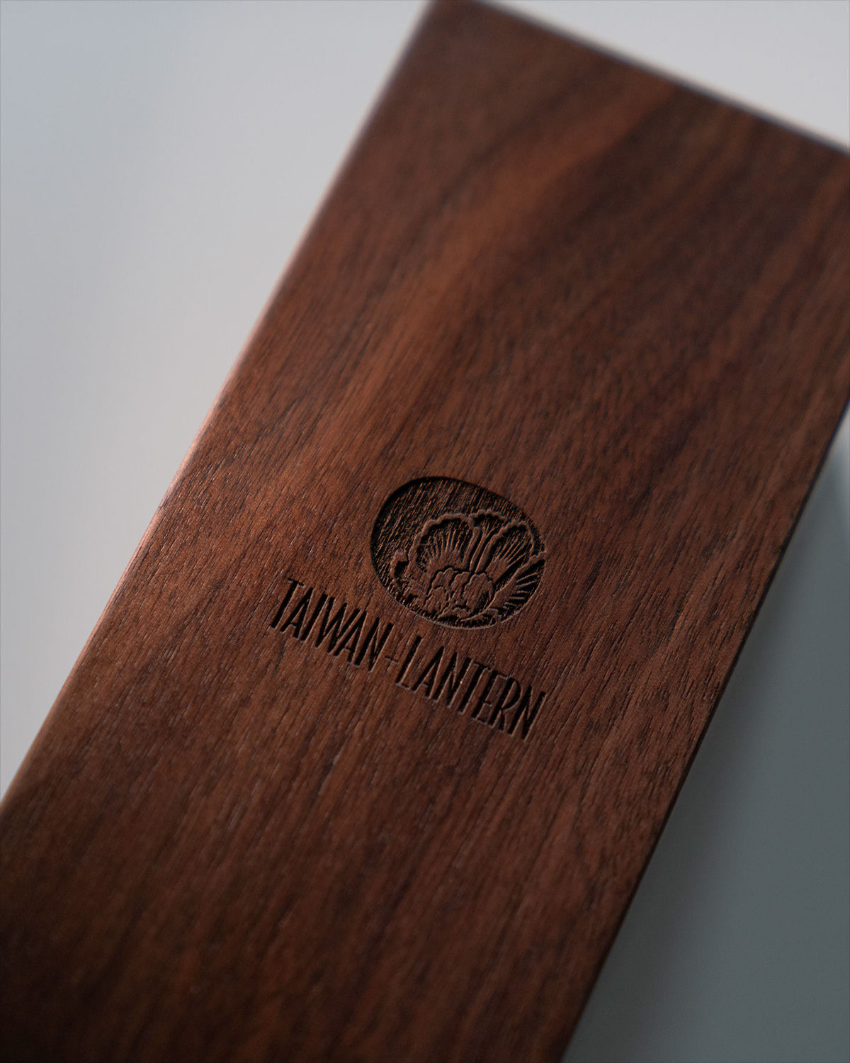 Taiwan-Lantern logo engraved detail on dark walnut wood surface