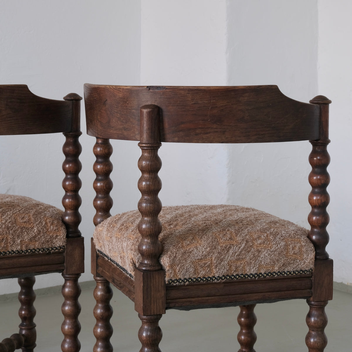 Close-up of antique bobbin turned wood legs and upholstered seat