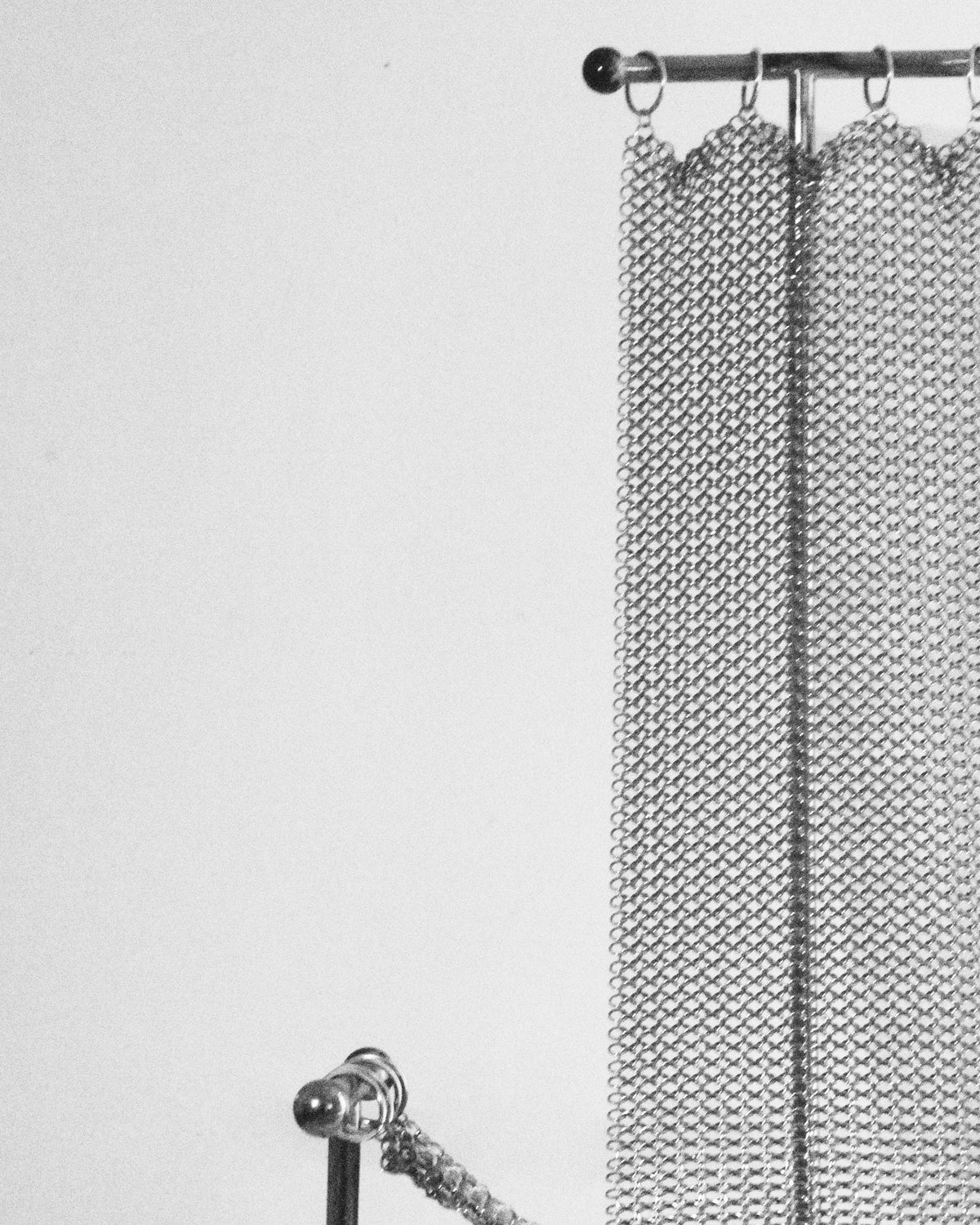 Steel chainmail armchair detail showing mesh texture and rod support