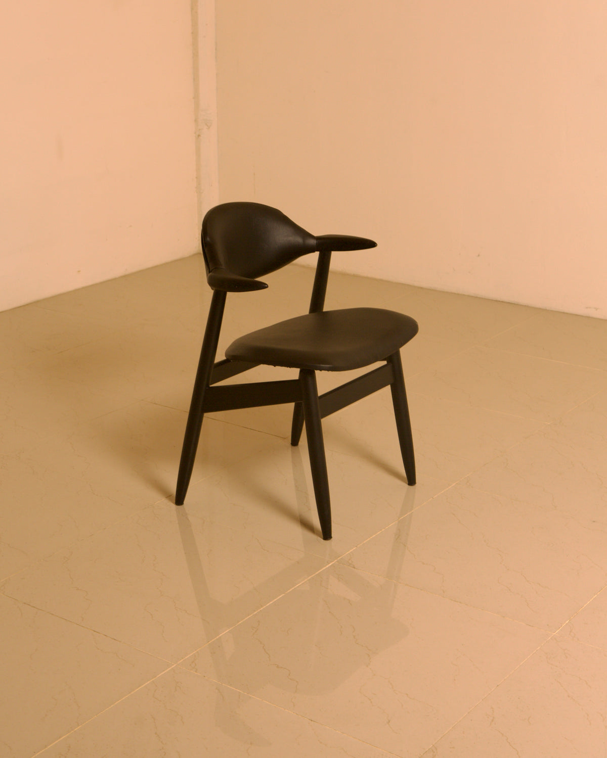 Dutch "Buffalo" Armchair in Wood and Black leather, 1960s — back view on polished floor