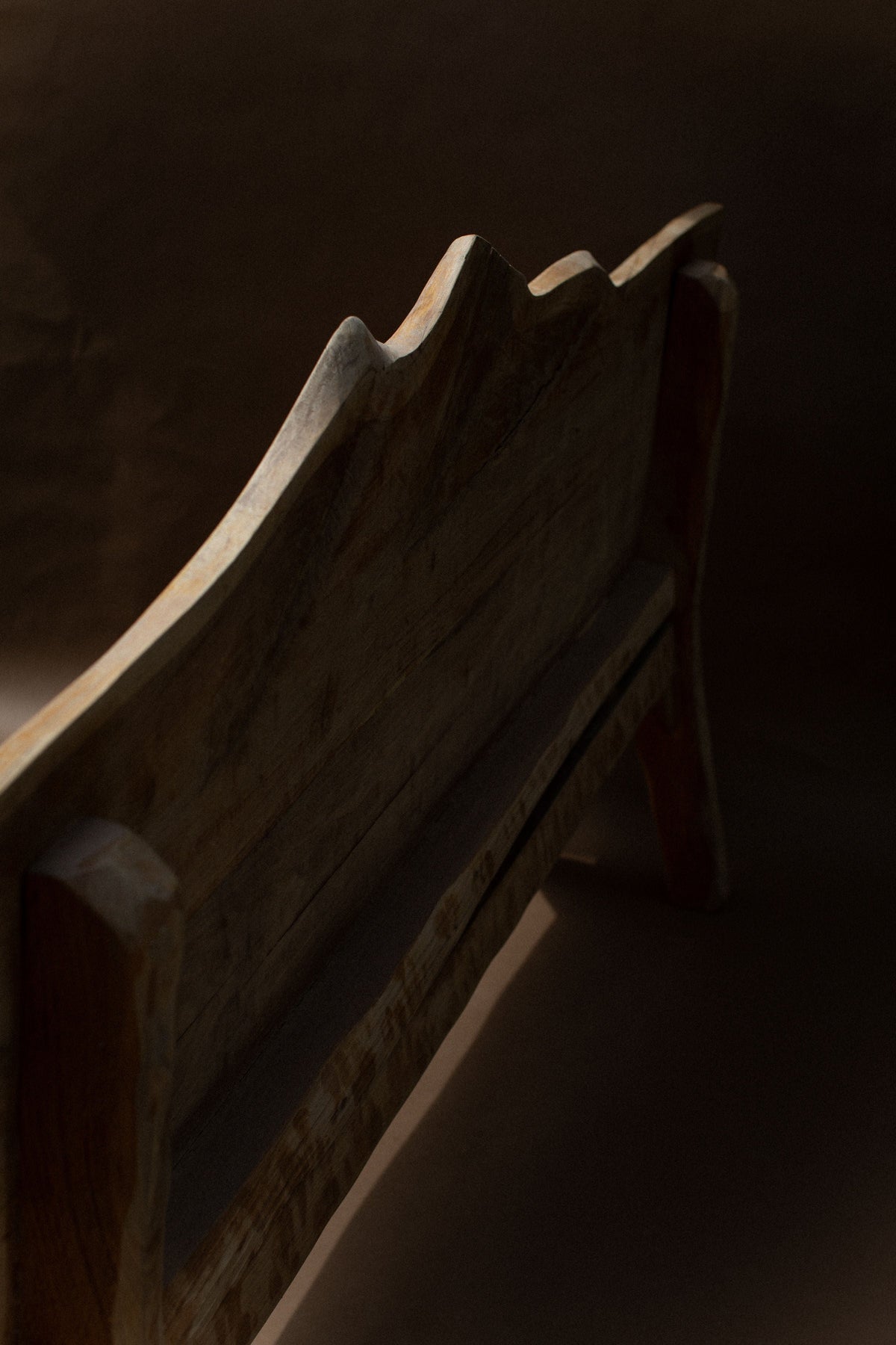Dark walnut brutalist bench with angular geometric edges detail