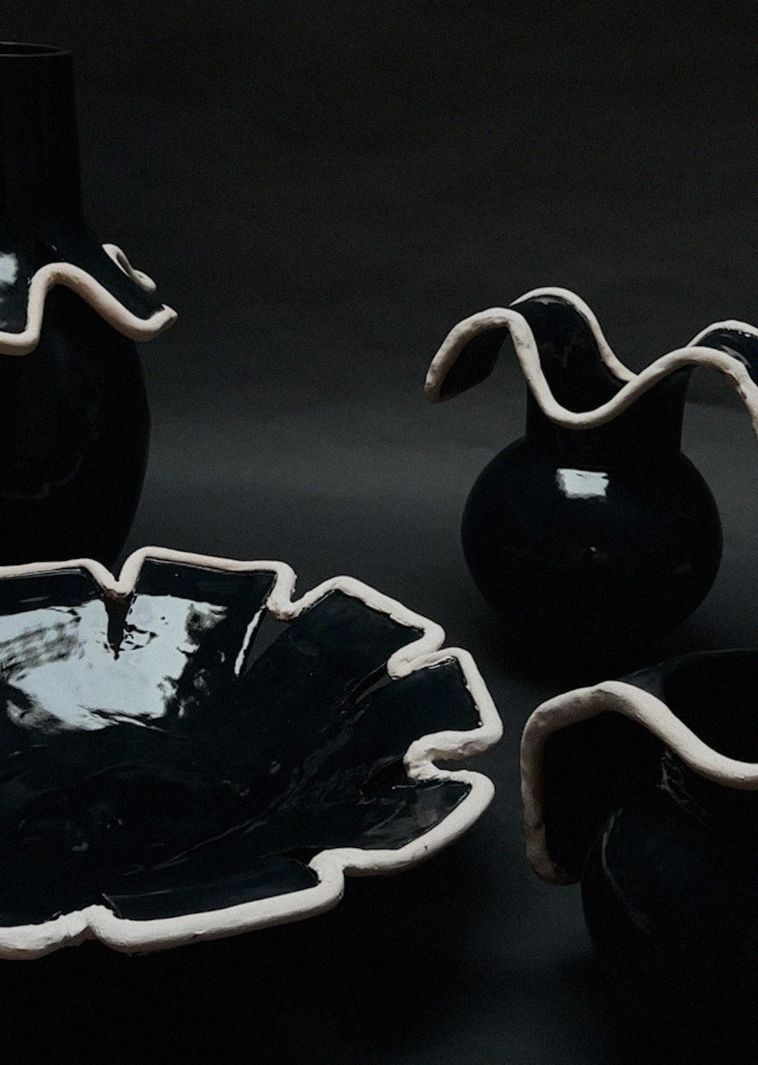 Navy blue ceramic collection with ruffled white-edged dish and vases