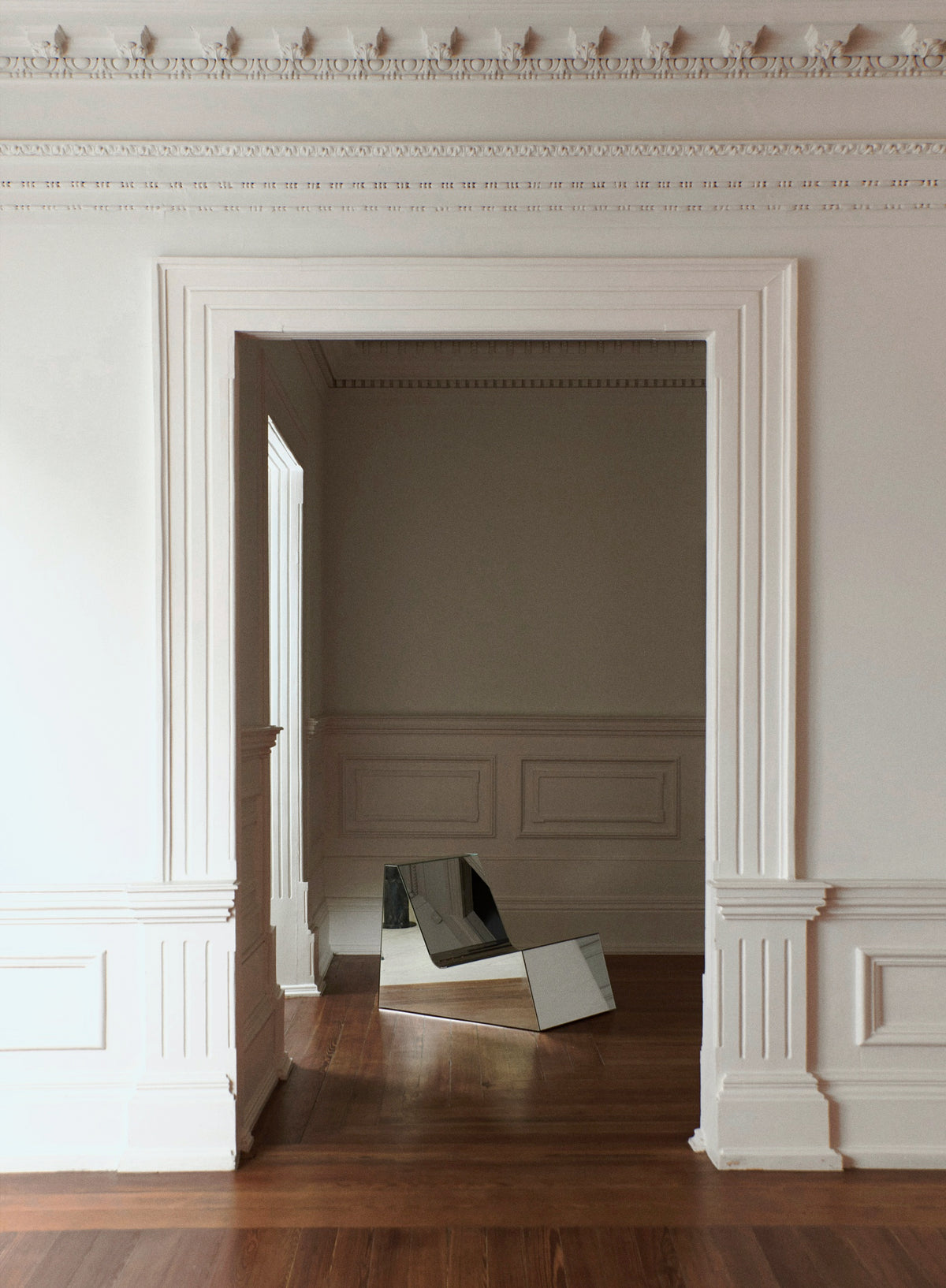 Mirror Lounge Chair — angled view in minimalist interior setting
