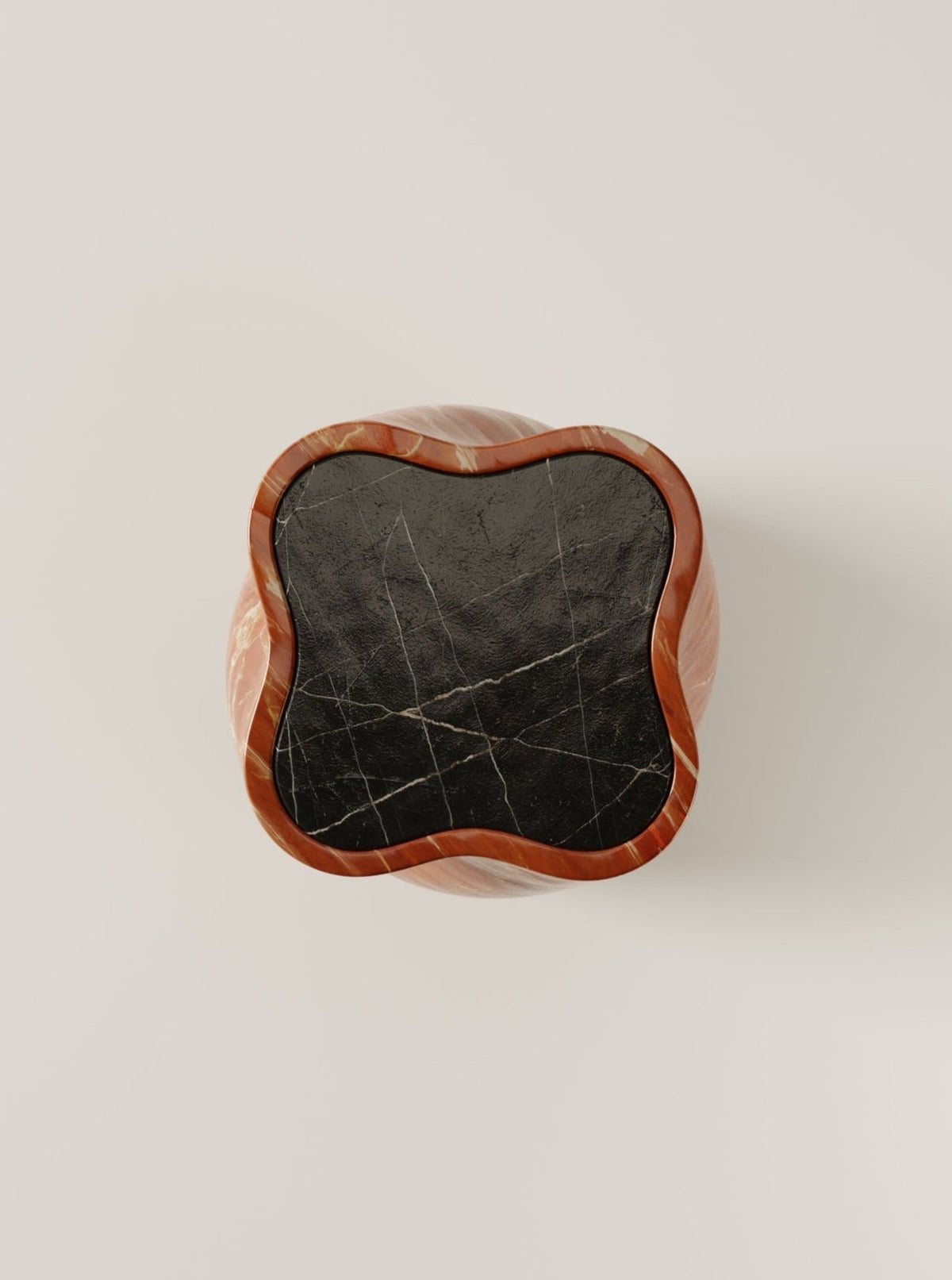A top-down view of the fUUUUsillo Rosso Alicante table by BURGIO., featuring a wavy nero marquina marble surface framed by reddish-brown wood, set against a light background.