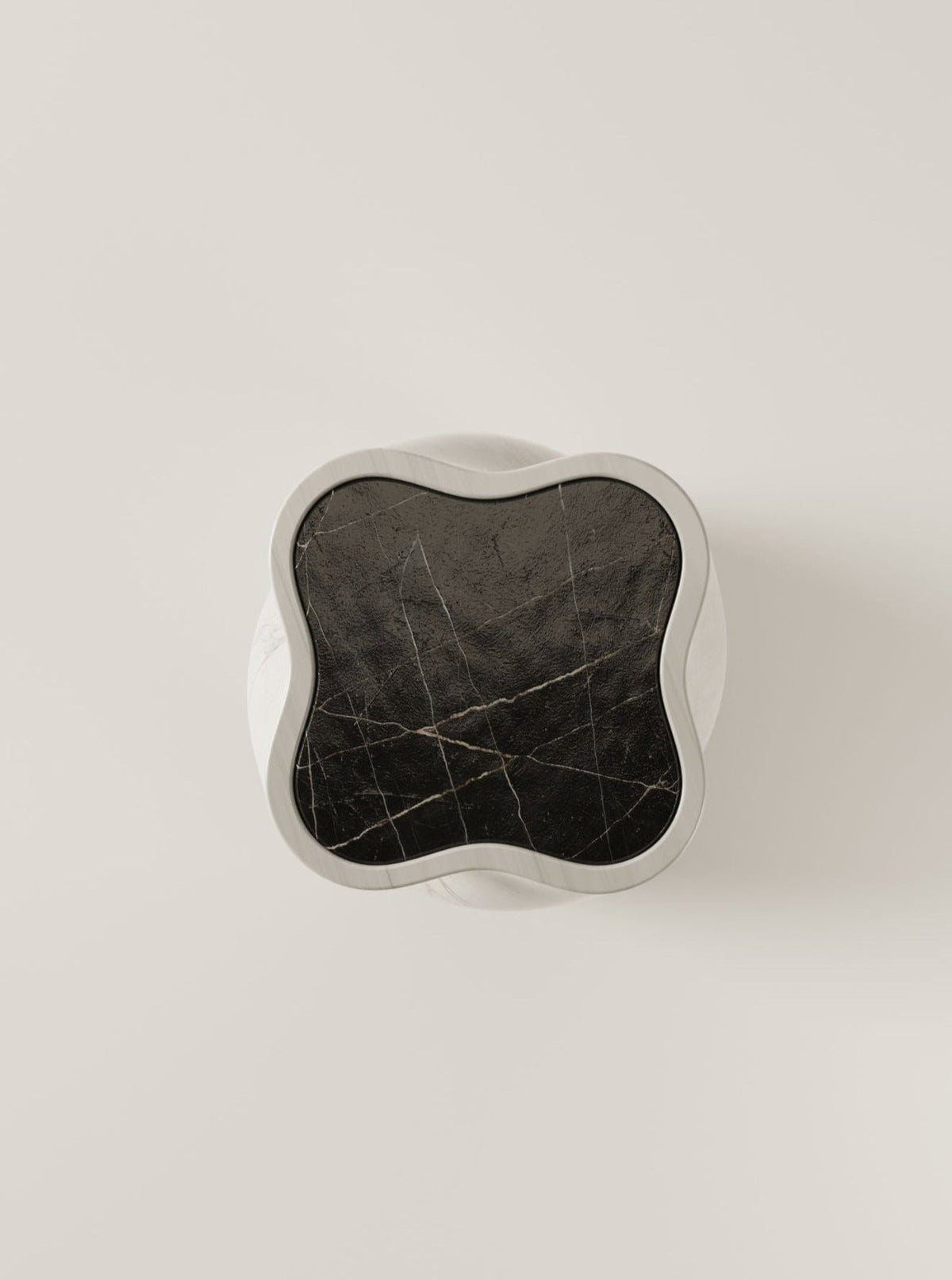 The BURGIO. fUUUUsillo Arabescato features a round white base topped with a wavy-edged, square Arabescato marble slab, detailed with subtle veining, and is shown from above against a plain light backdrop.