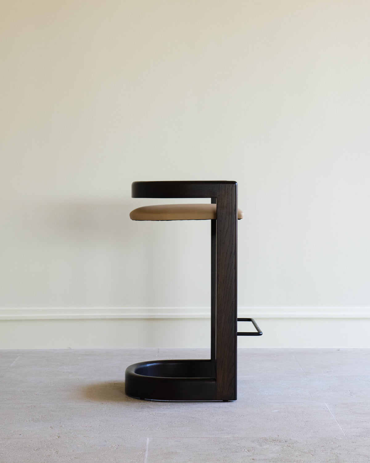 Modern cantilever barstool with black wood frame and tan leather seat