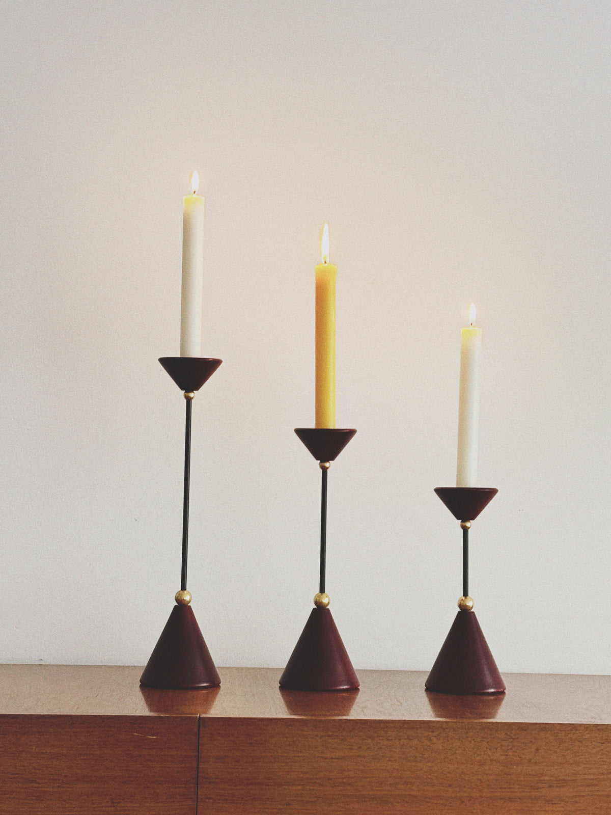 Set of Postmodern Candle Holders in Wood and Metal — side view on wooden surface