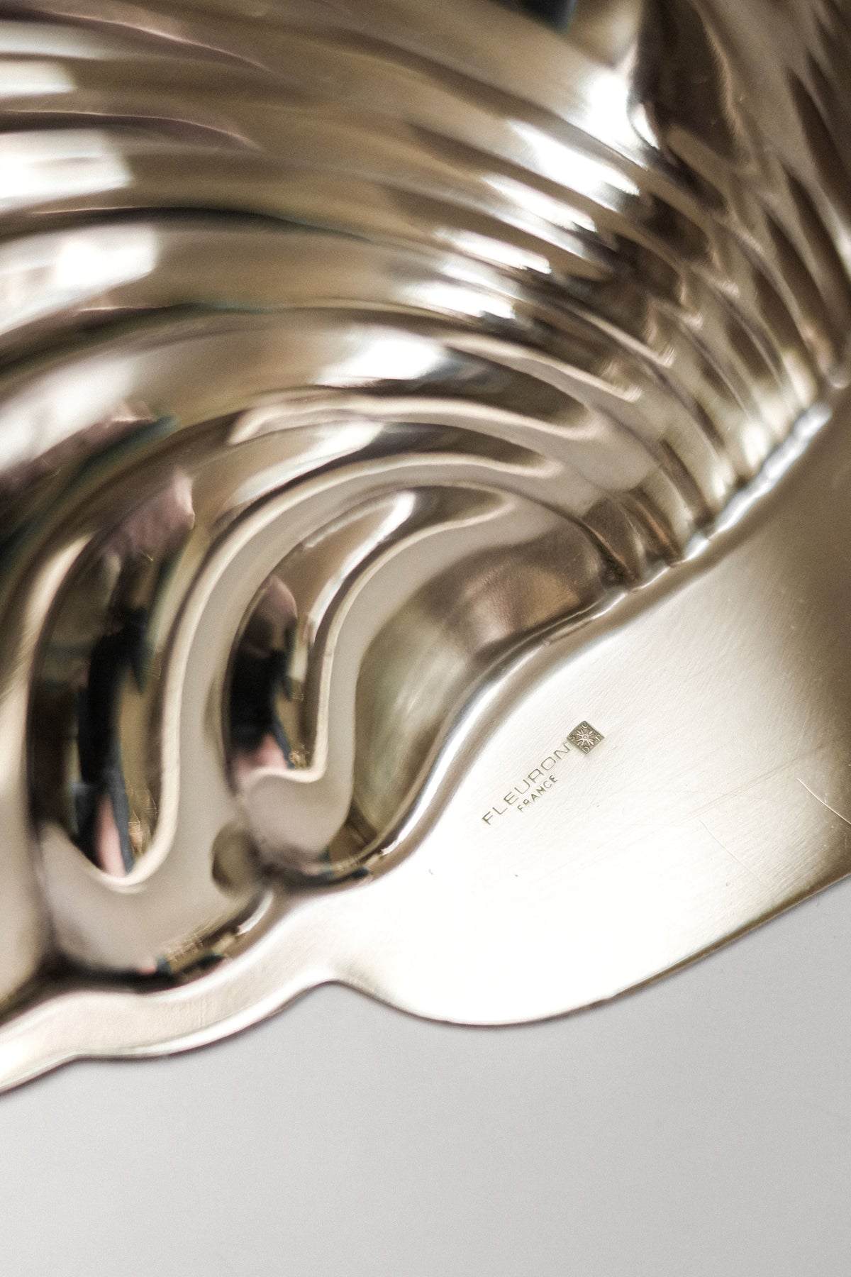 Medium Shell Shaped Vide-poches — side angle of polished metal surface