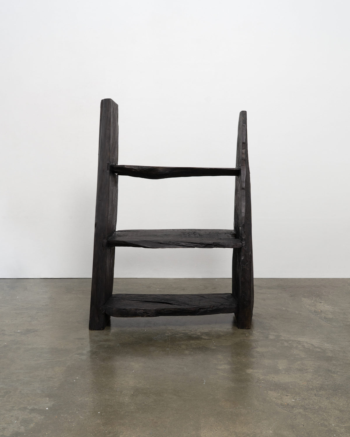 Dark wood brutalist bookcase with three open shelves and angular frame
