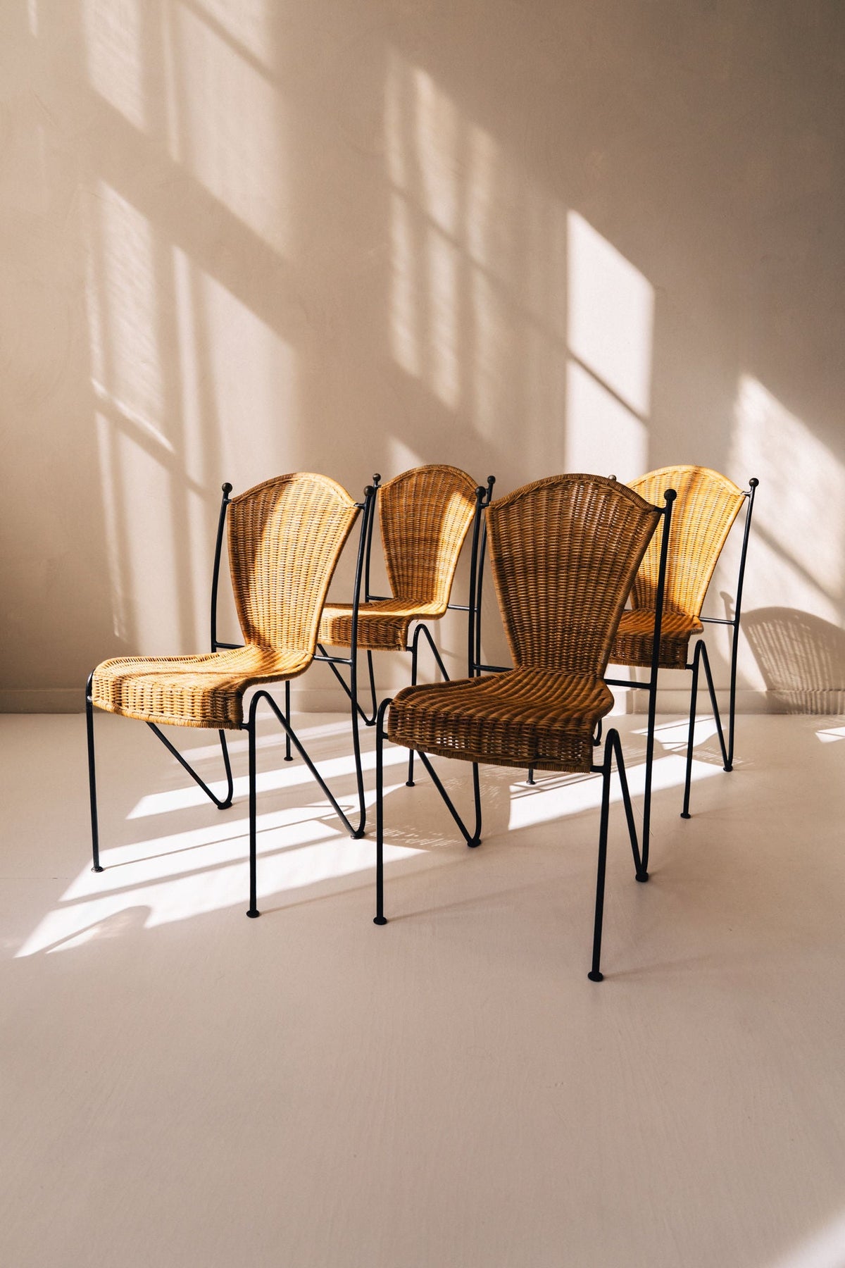 Four vintage Frederic Weinberg wicker chairs with black iron frames