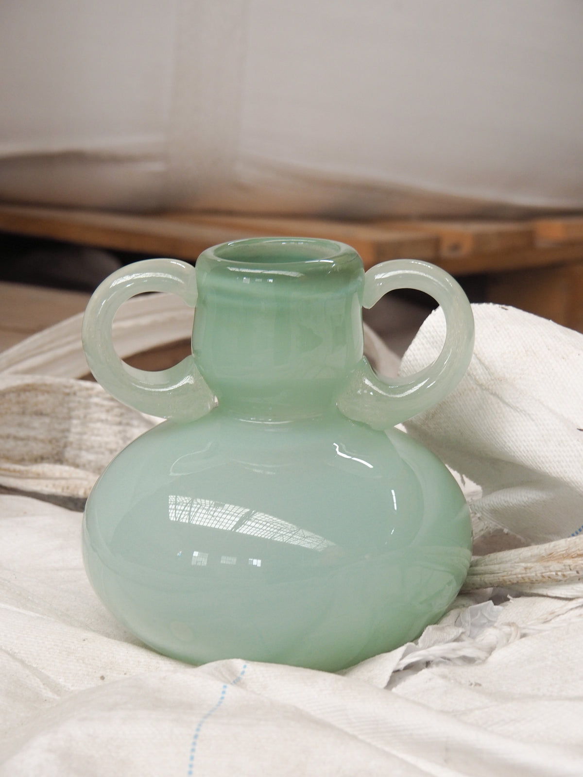 The Vase 03 — close-up of mint green glass with handles