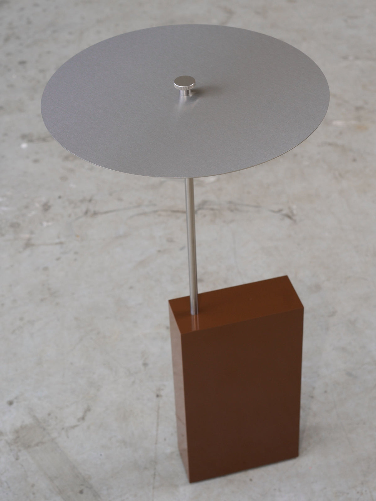 The Assistant' Side Table — angled view showing metal top and brown base