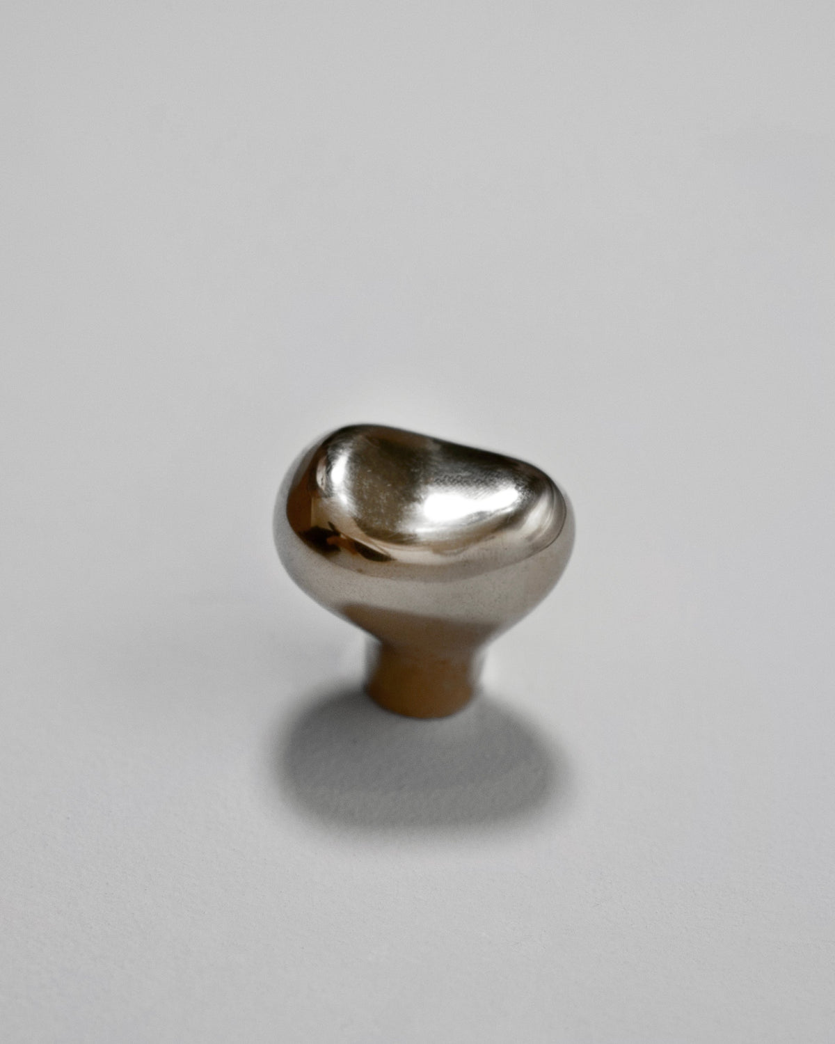 Rud Knob - Titanium — angled view on light gray surface