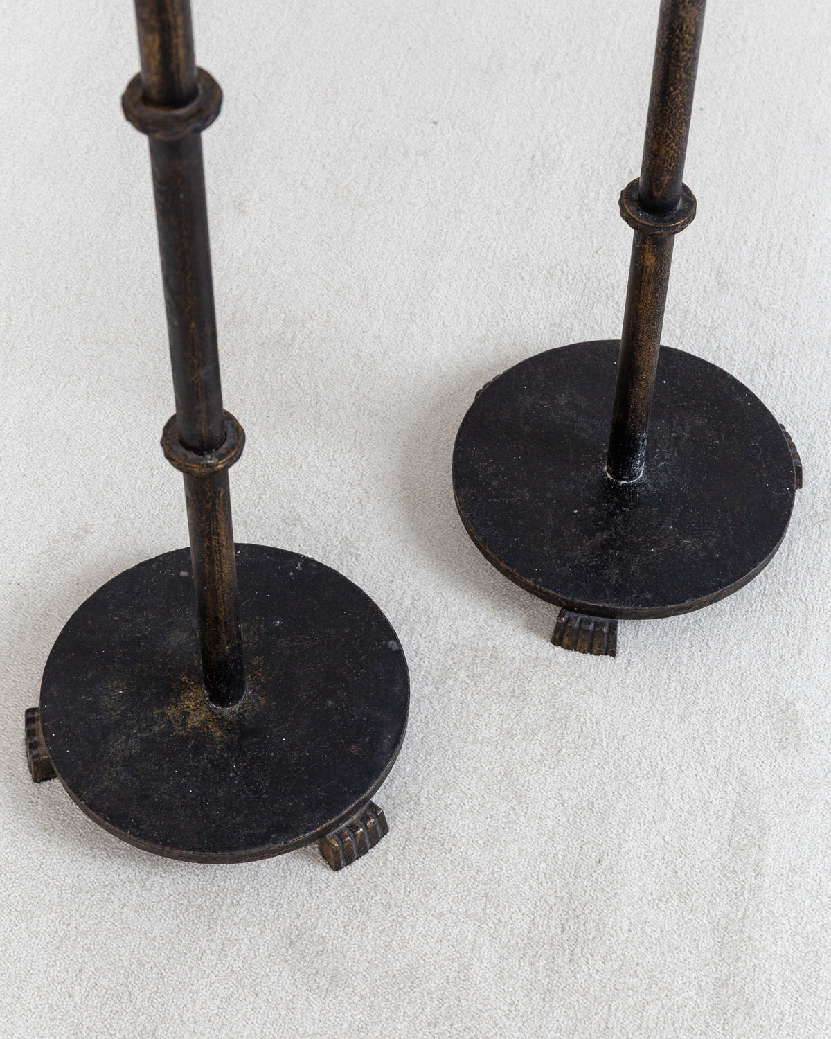 Pair of Monumental Cast Iron Floor Candleholders by Böhlmarks, Sweden, 1930s — close-up of round bases on light fabric backgr