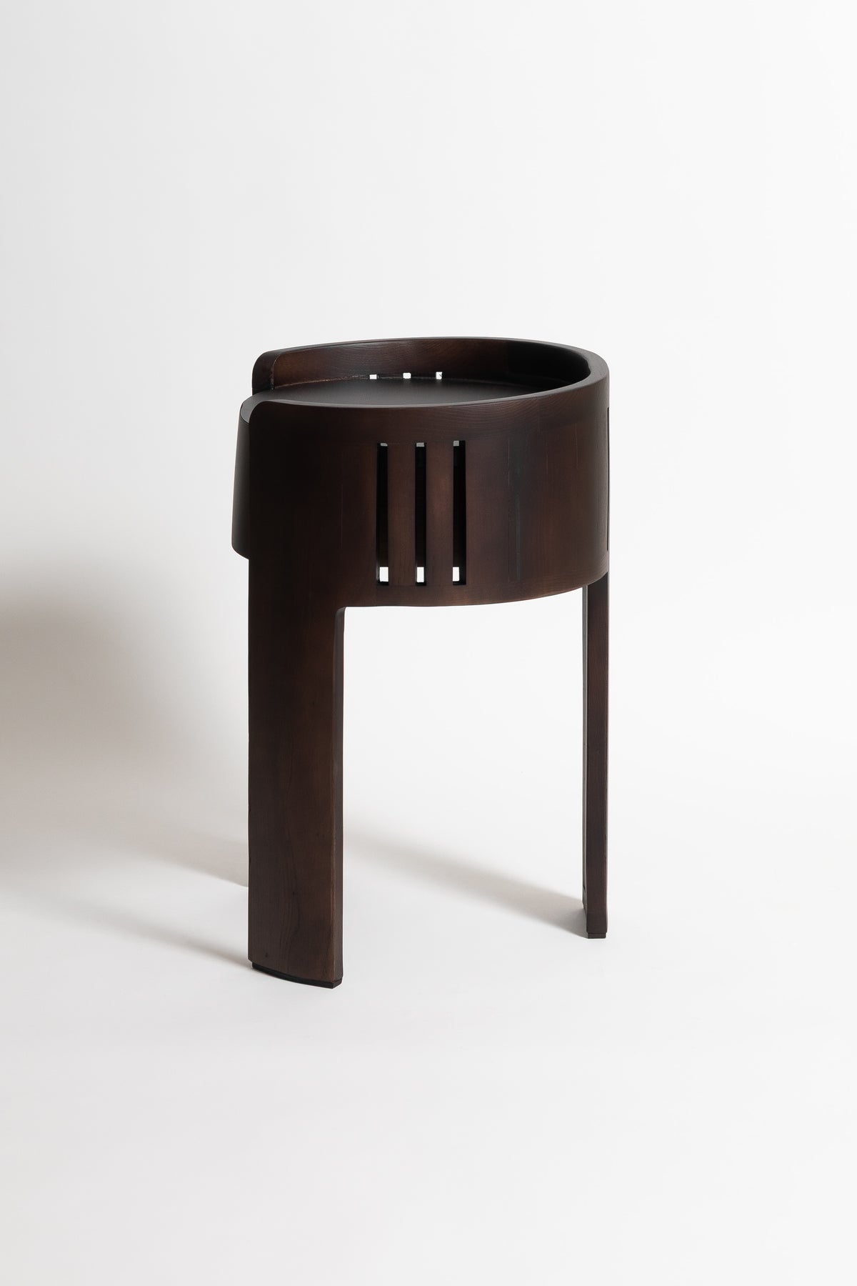 Modern dark wood nightstand with curved cylindrical top and vertical slat details