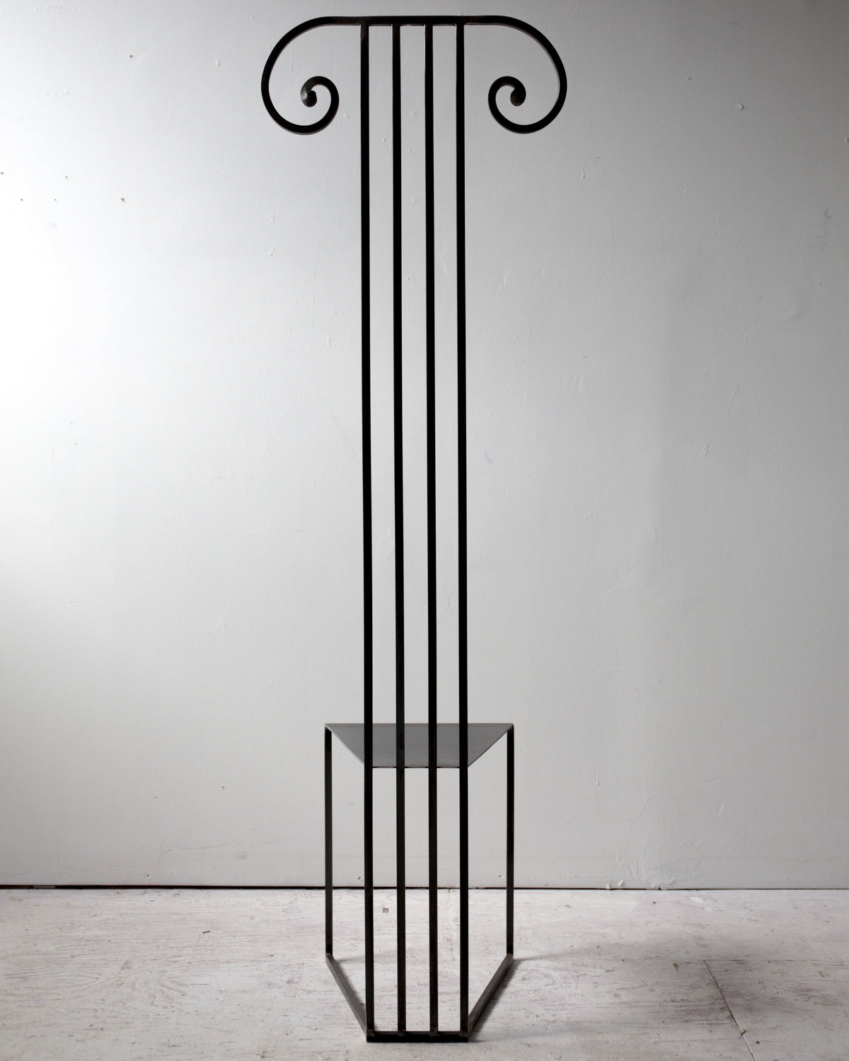 Minimalist black metal column chair with ionic capital design