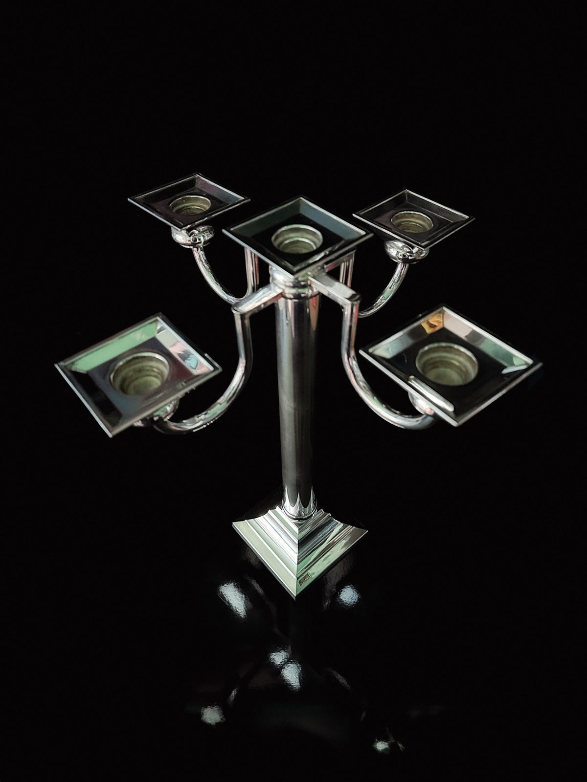 A Silver Plated Art Deco Candelholder 80s by Dodo Vintage, featuring five square holders, is shown against a black background with a striking reflection below.