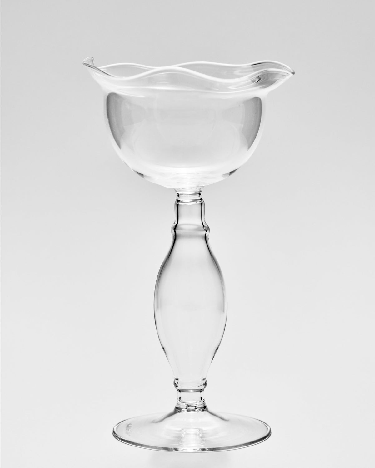 Clear glass wine goblet with ruffled rim and elegant stem design