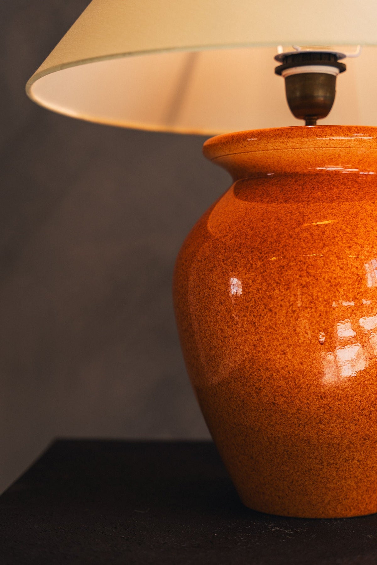 Orange ceramic table lamp with speckled glaze and white shade detail