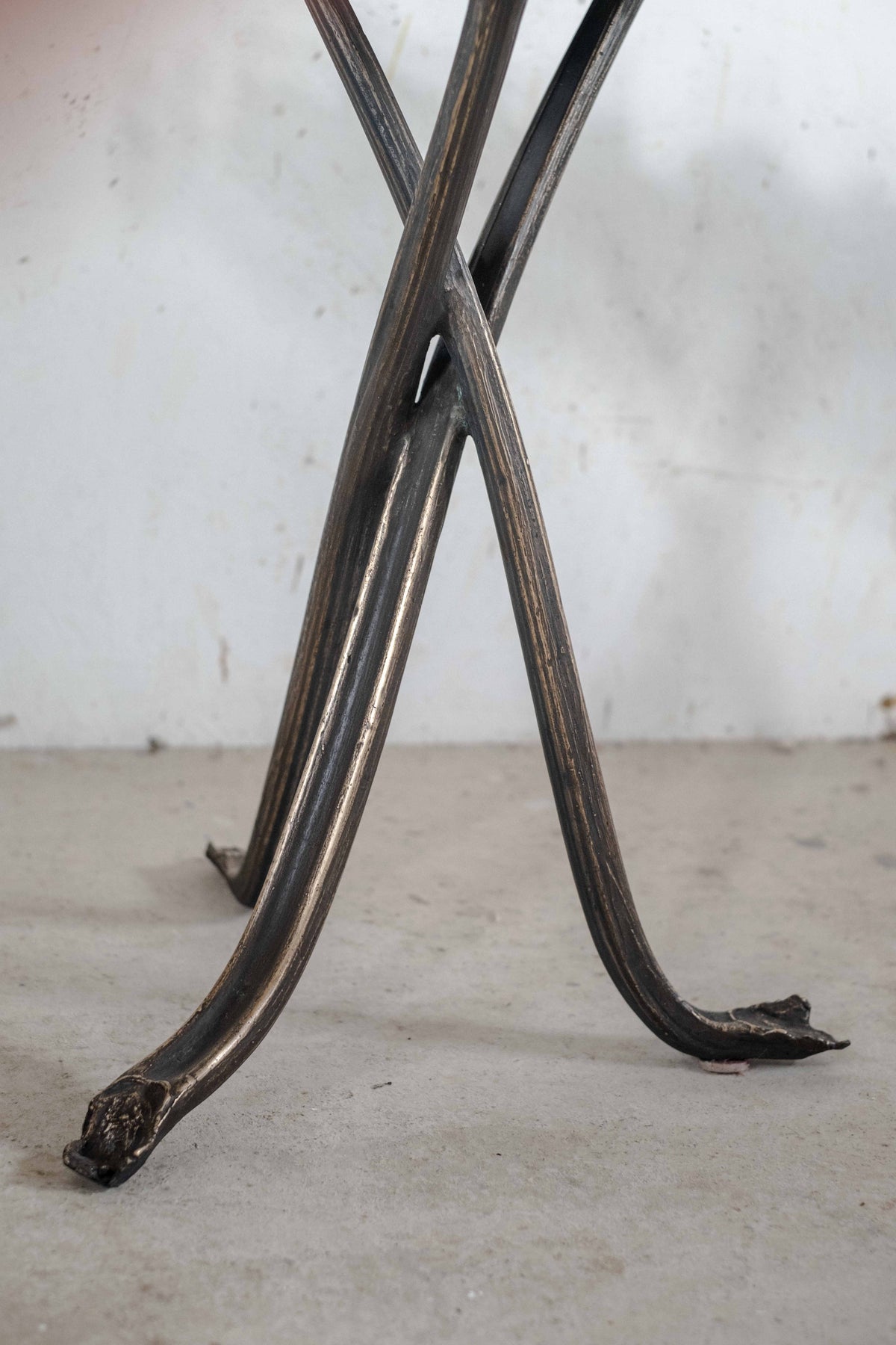 Bronze rhubarb table legs detail showing curved metal craftsmanship