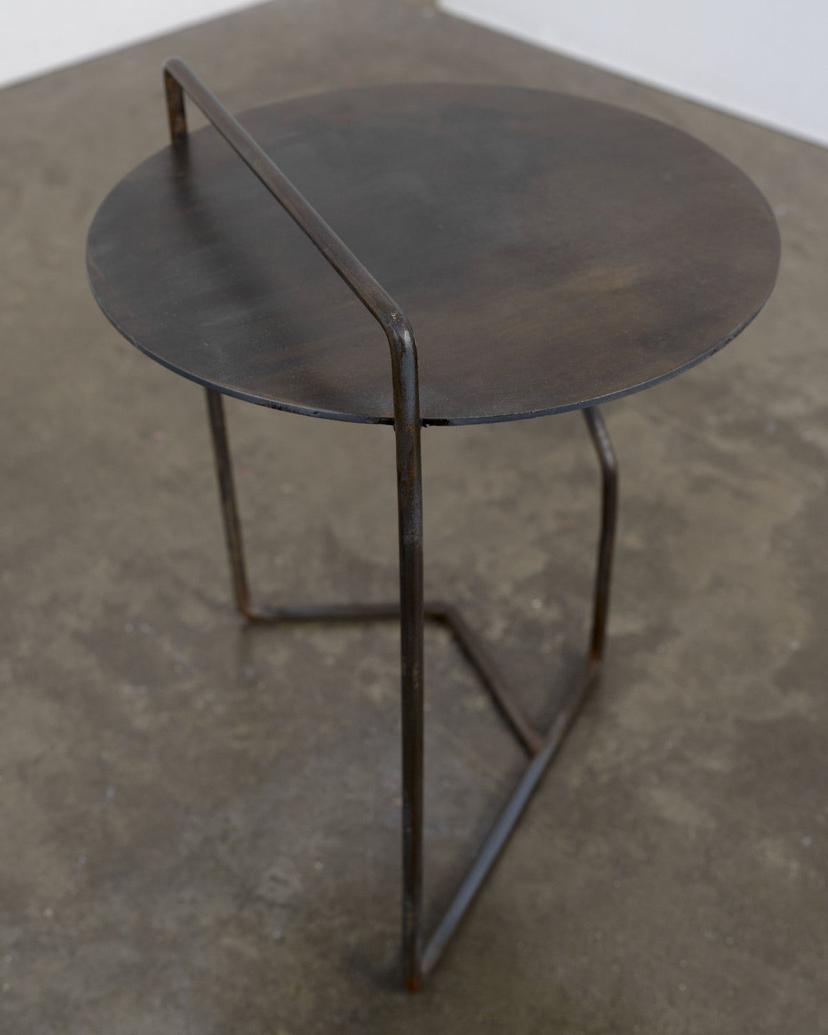 Sculptural Patinated Steel Side Table — top view of round steel surface