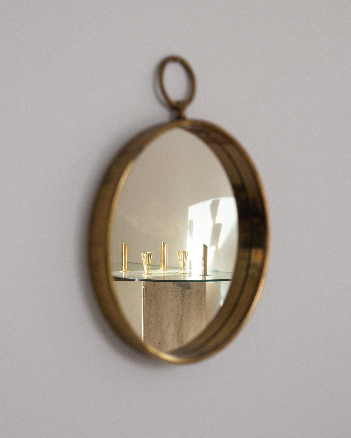 Scandinavian Mid-Century Round Brass Mirror — angled view reflecting modern decor