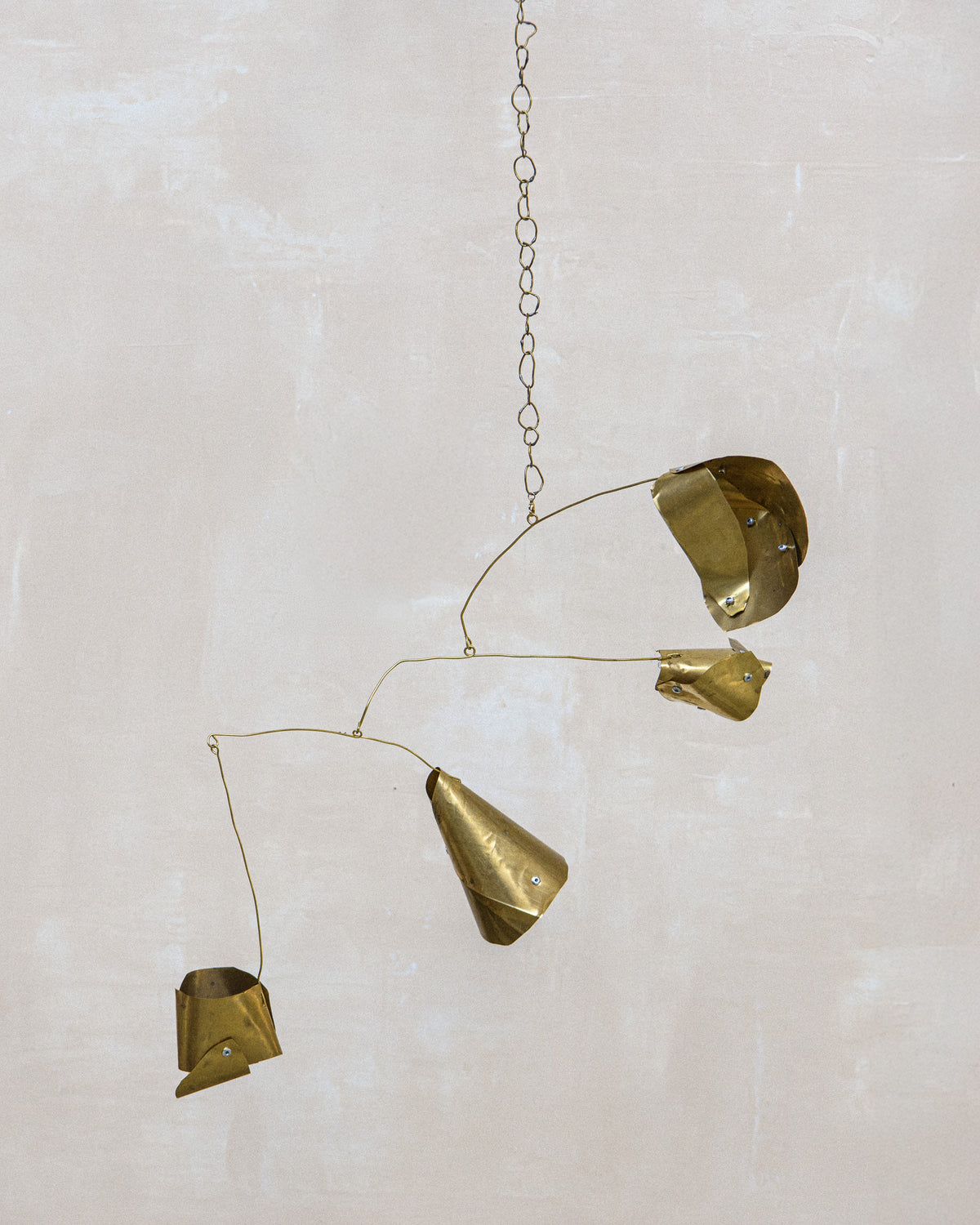 Abstract brass mobile sculpture with geometric forms suspended on delicate chains