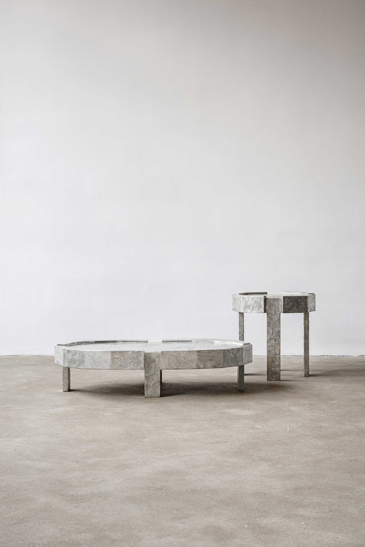 Splav Tin Table (smaller) — side angle showing gray tin material on concrete floor