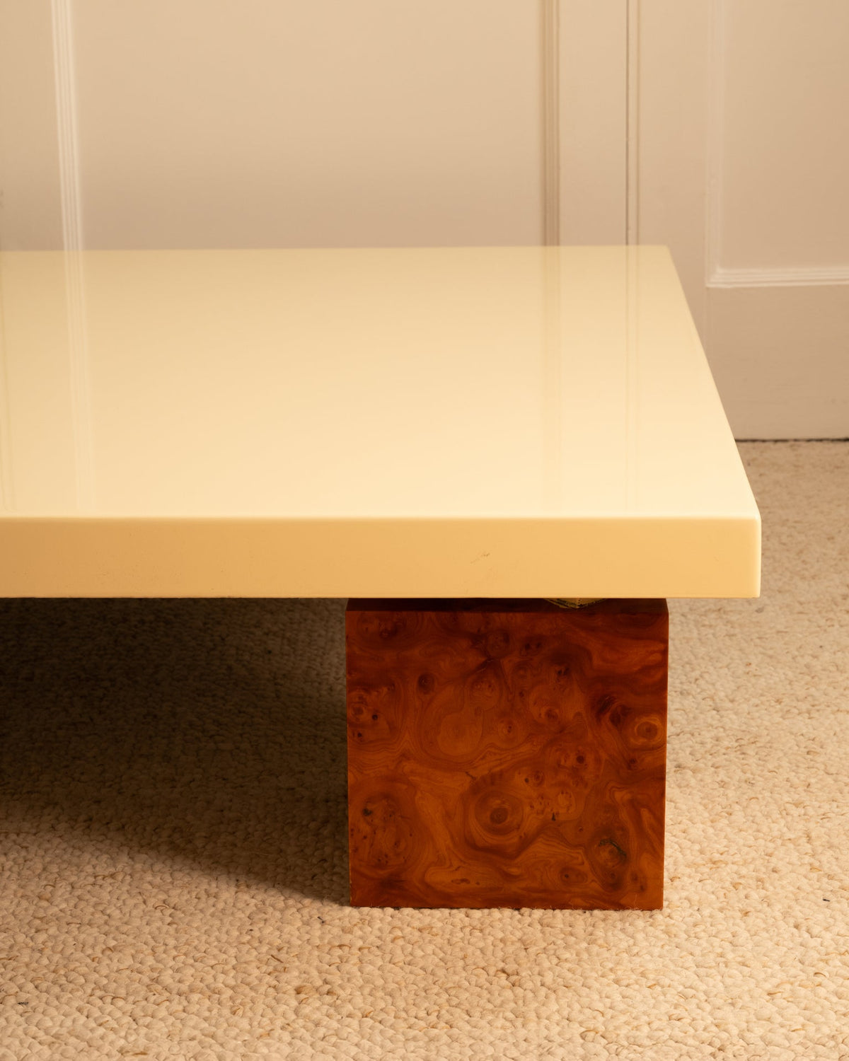 Detail view of 1970s wooden table with cream lacquered top and burl wood base