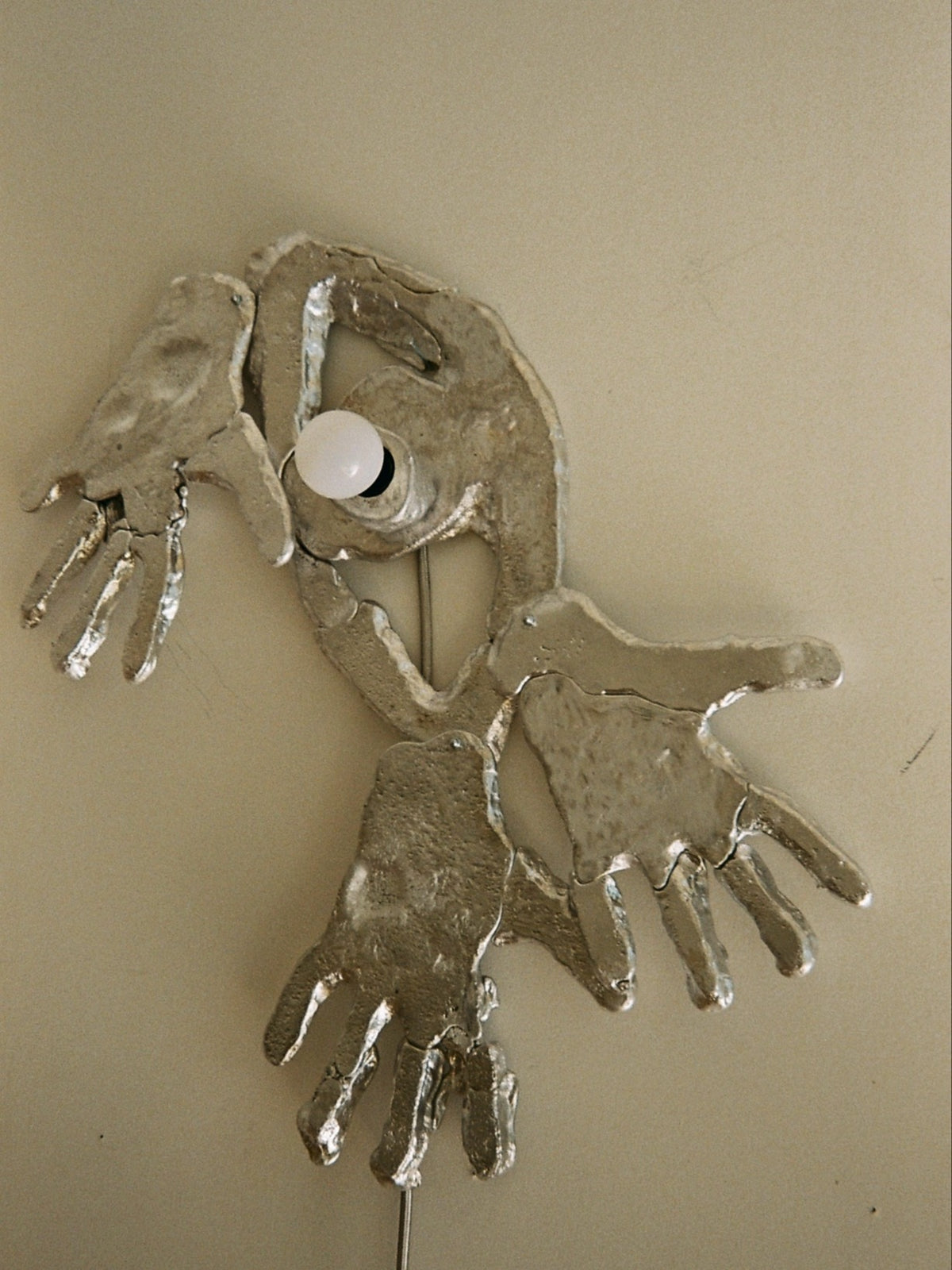 Sculptural wall lamp with organic form and metallic finish detail