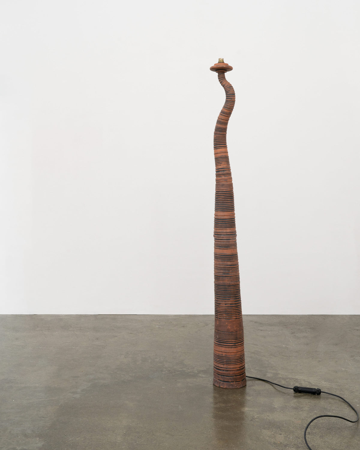 Curved terracotta floor lamp with stacked disc construction