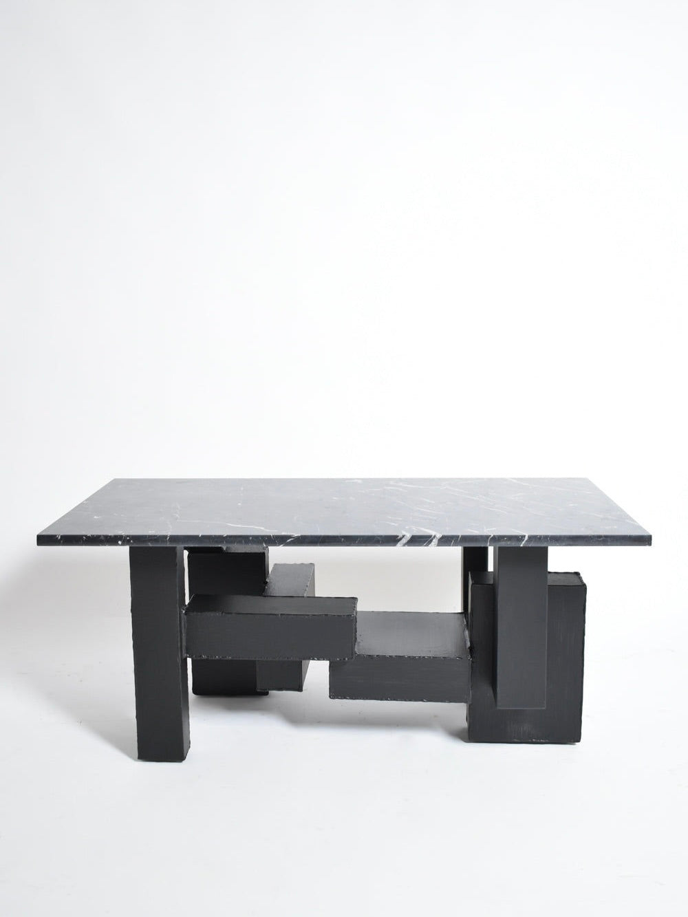The Barracuda Interiors Cubist Iron and Marble Coffee Table (1980s) features a rectangular black marble top and geometric iron block base, showcased against a plain white background.