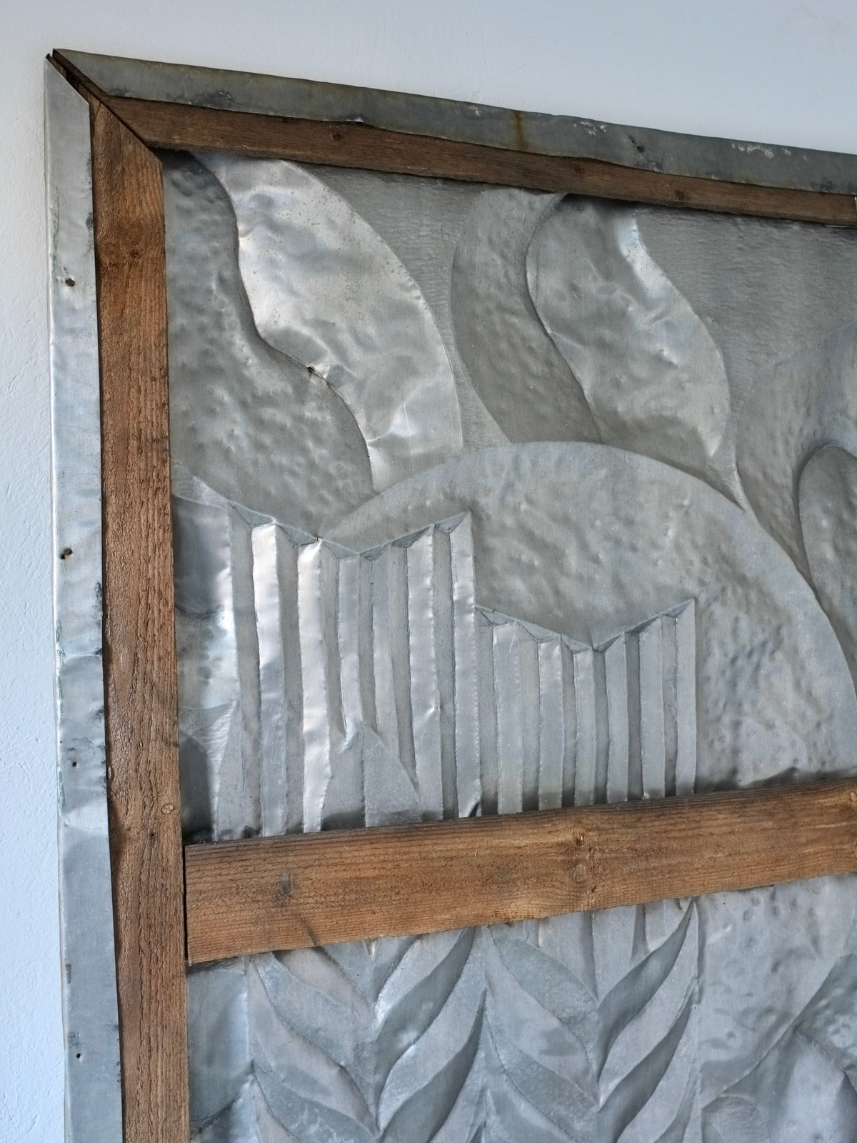 Large brutalist metal relief sculpture detail showing geometric leaf motifs