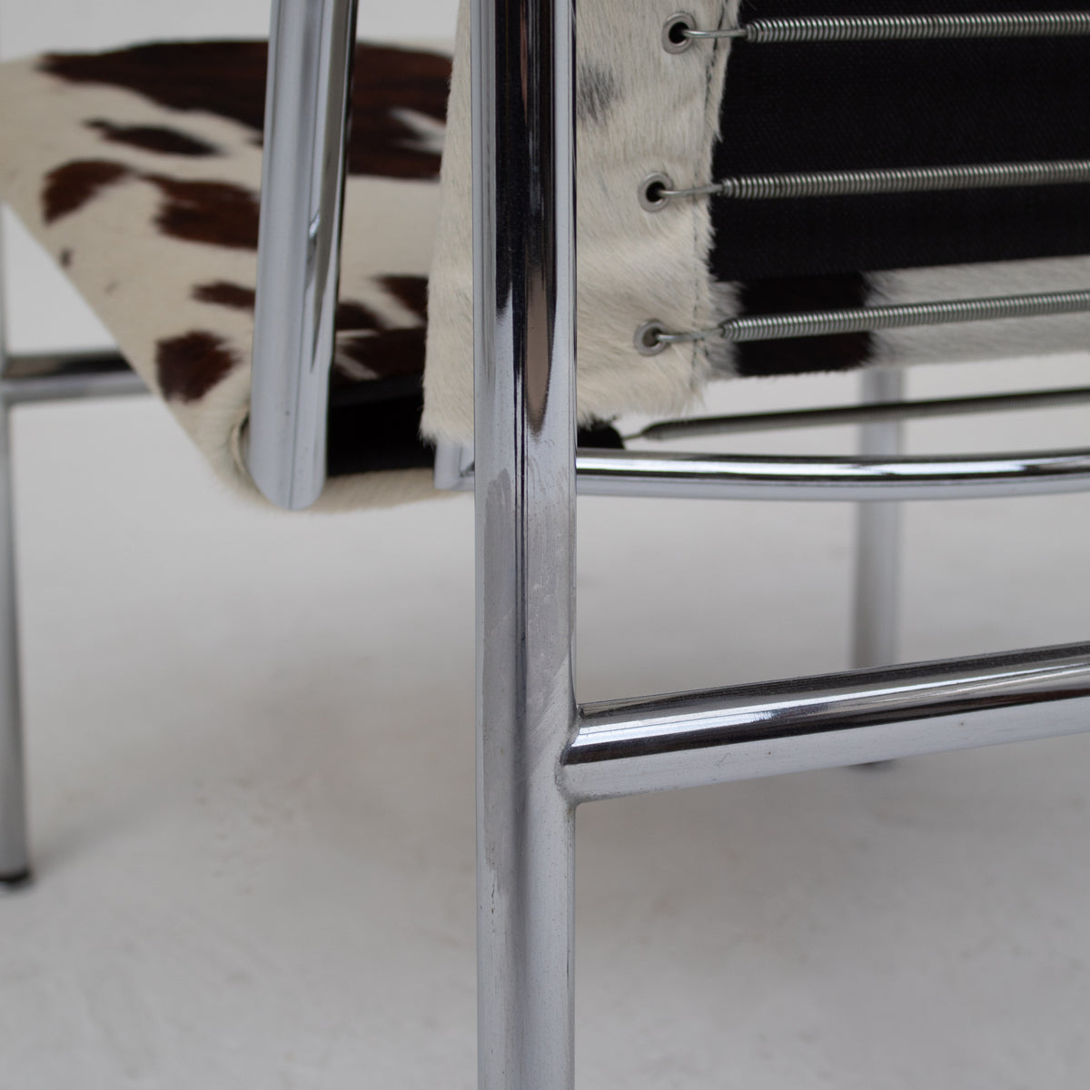 Le Corbusier, Pierre Jeanneret, Charlotte Perriand LC1 Chairs by Cassina — close-up of chrome frame and cowhide seat
