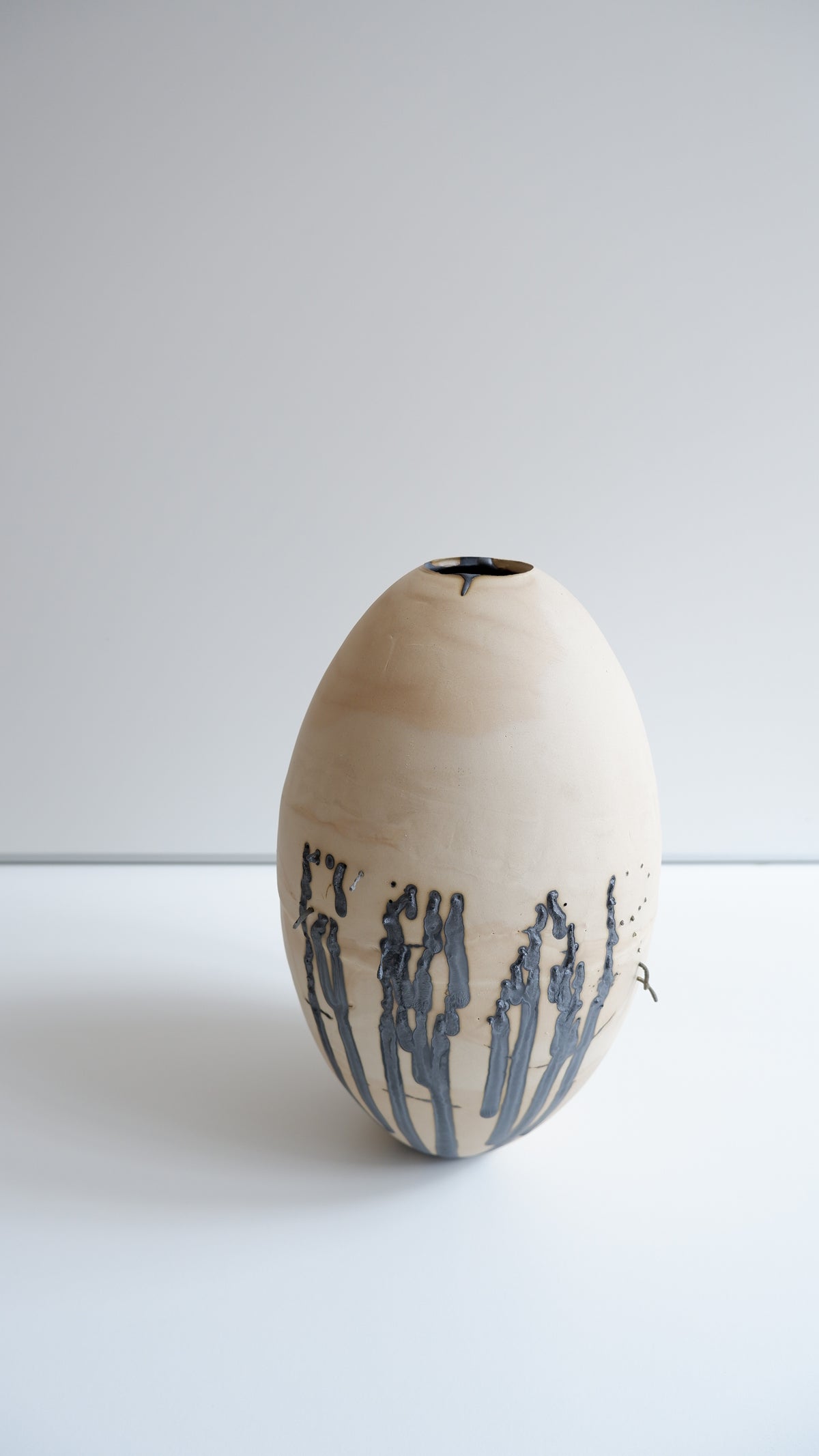 FEAR Vessel — side angle showing natural clay with black detailing